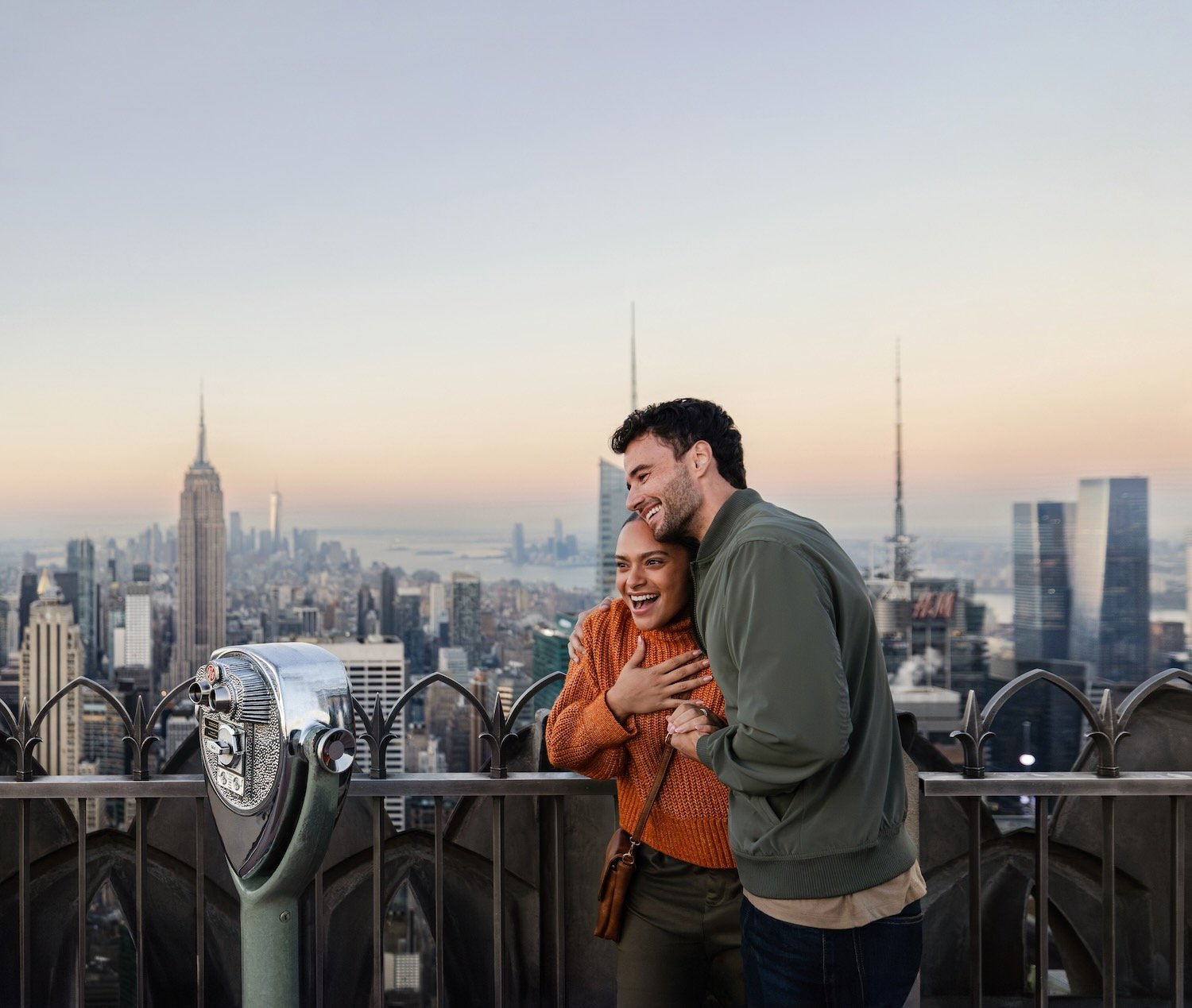 Two travelers takes in the Manhattan skyline from the Top of the Rock.