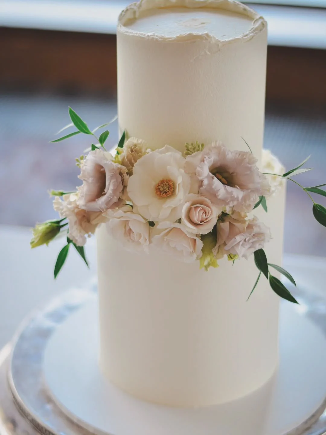 A simple buttercream cake elevated by placing beautiful fresh flowers centrally for a slightly more modern look.