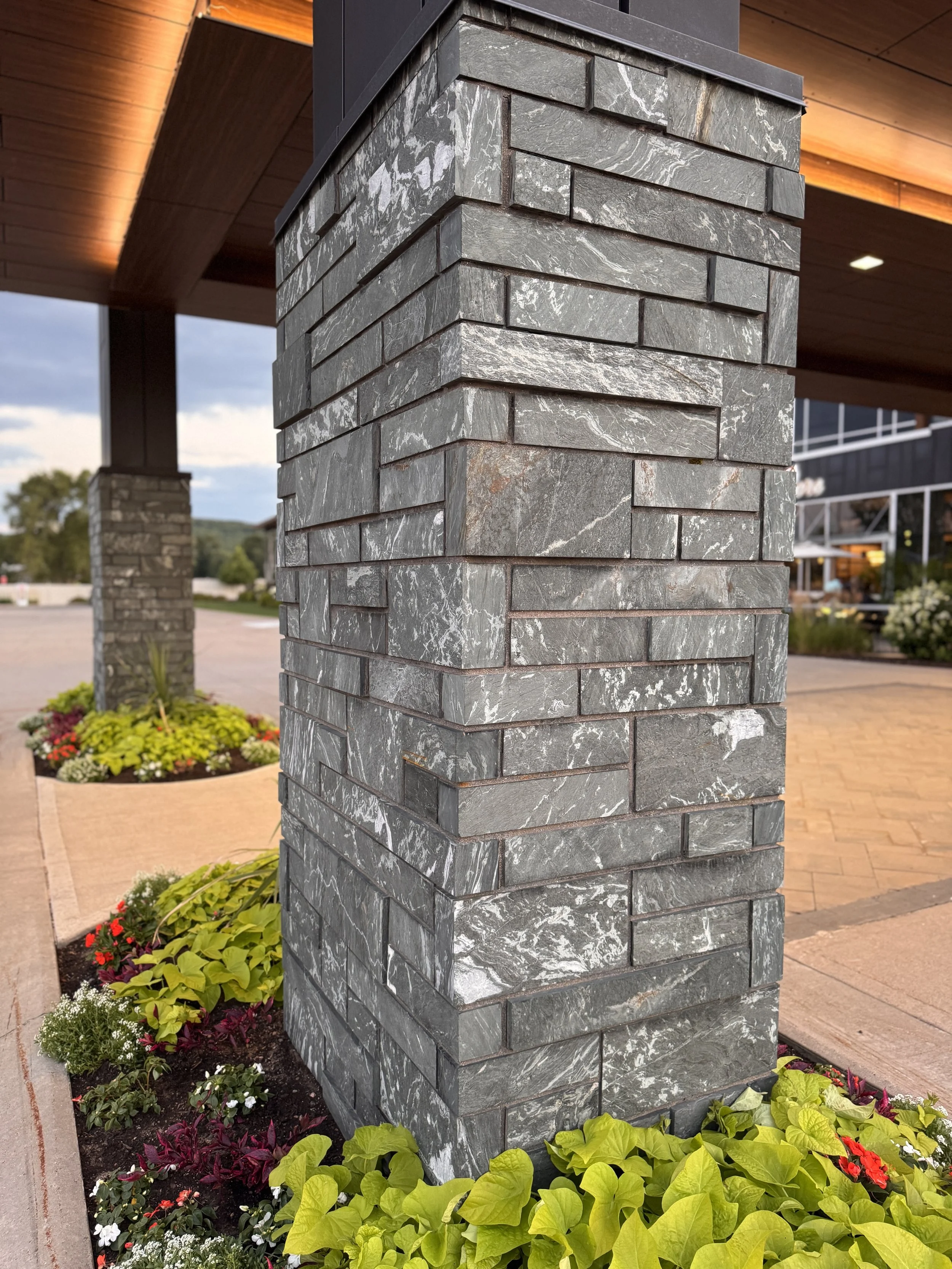Aqua Grantique sawn height 3 1/2" & 7 1/2" full veneer.  The stone was intentionally set with varying projections to create depth, texture, and visual interest across the façade.