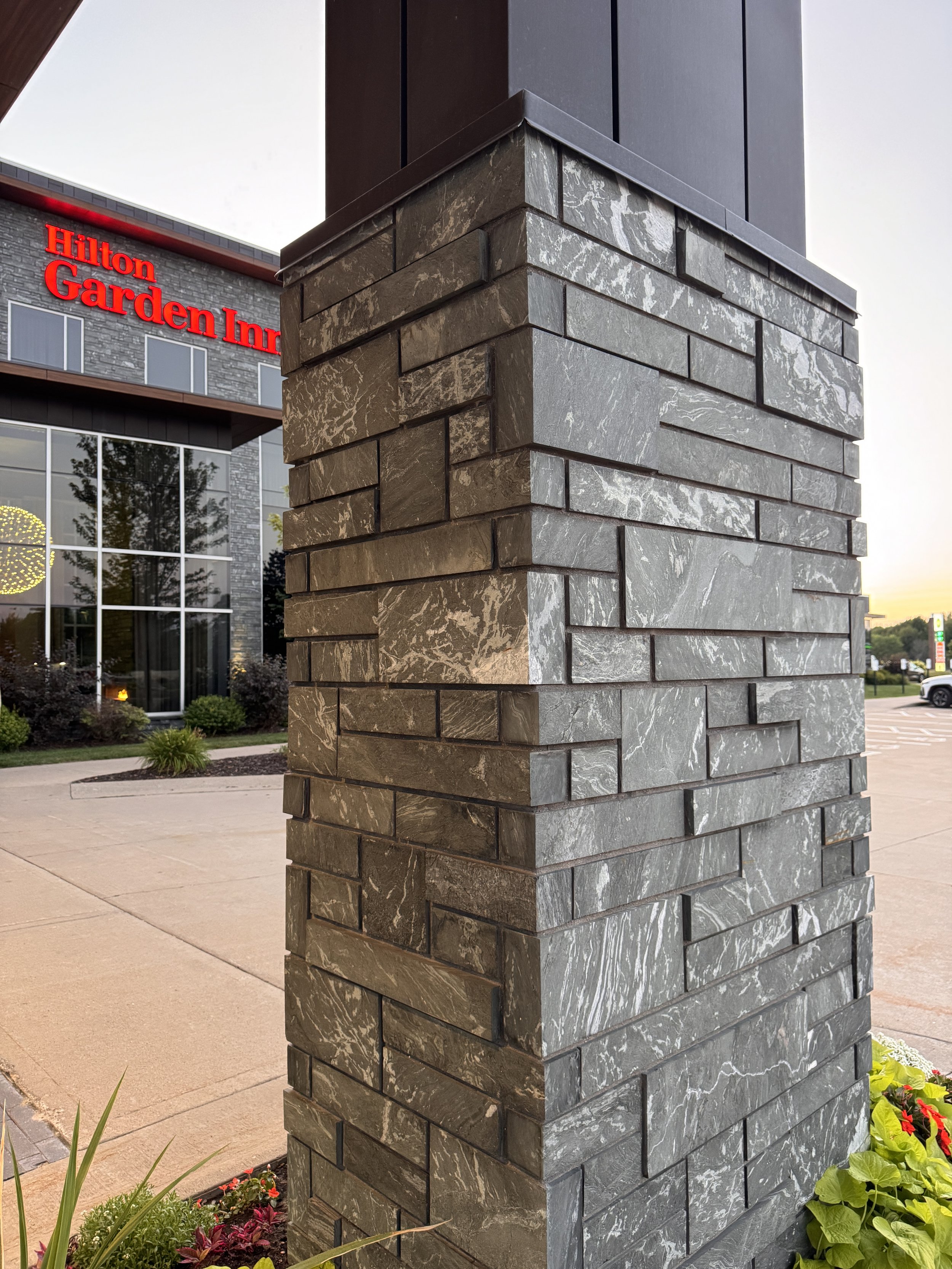 Aqua Grantique sawn height 3 1/2" & 7 1/2" full veneer.  The stone was intentionally set with varying projections to create depth, texture, and visual interest across the façade.