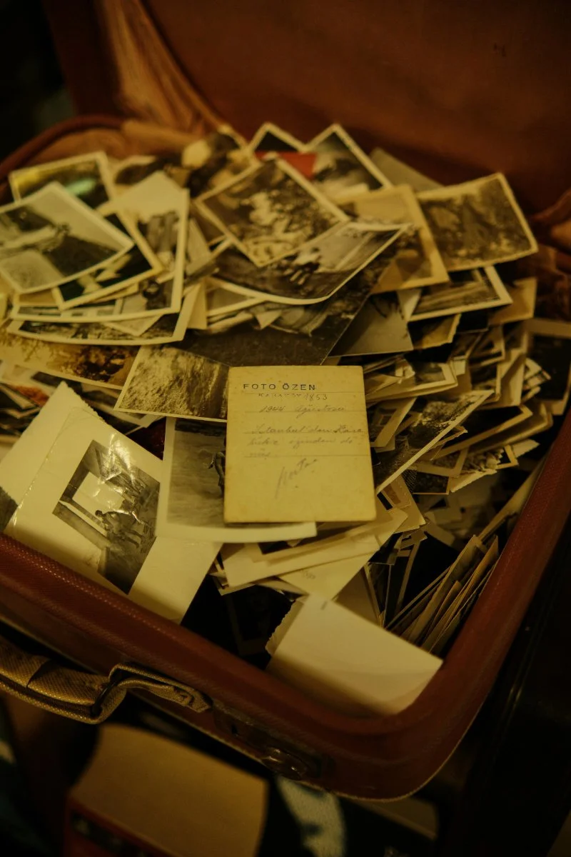 A collection of old family photos and unknown pictures spread across a surface, showing a mix of black and white and faded prints.