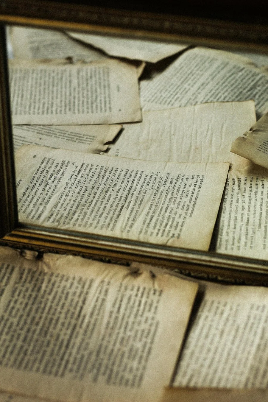 Stack of old historical documents in a frame, illustrating accessing court records and probate files for deeper genealogy research.