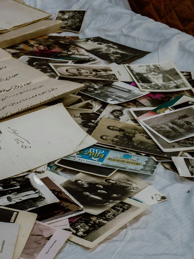 Close up of old photographs scattered on a bed