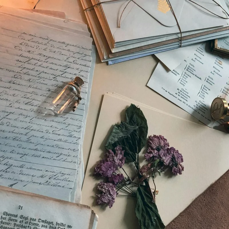 dried flowers and vial on old papers