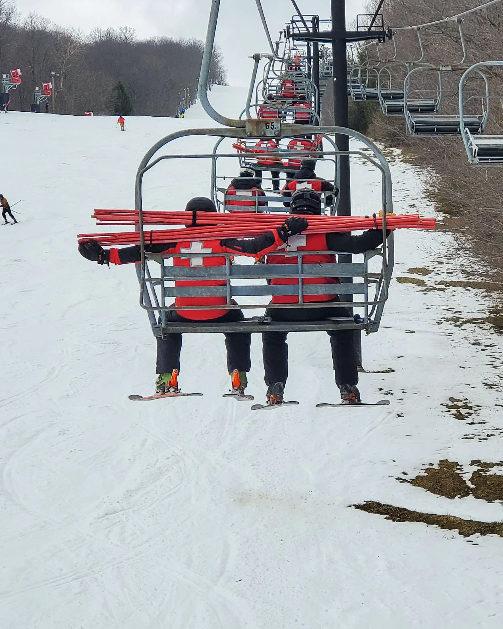 ski patrollers riding lift