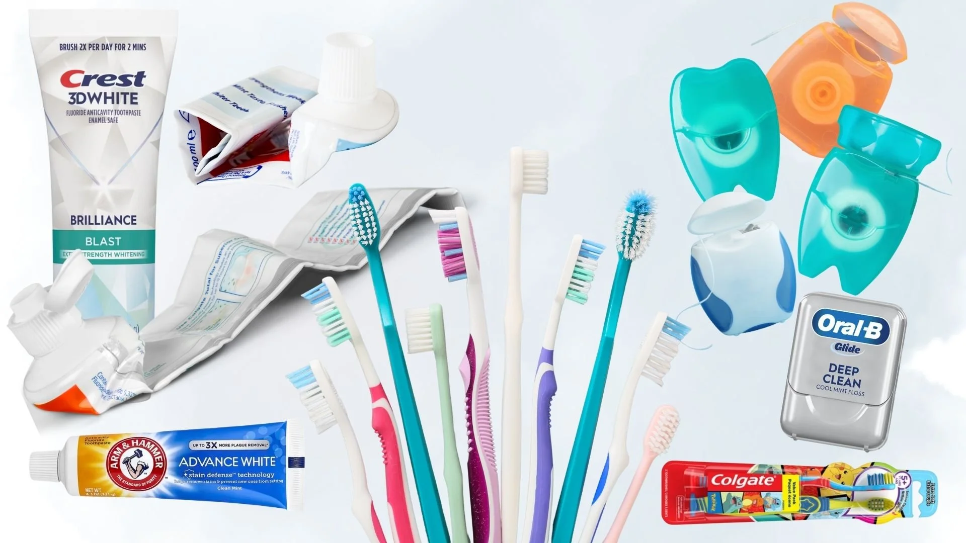 Various oral care products, including toothbrushes, toothbrush packaging, floss, and toothpaste tubes - some of which are empty