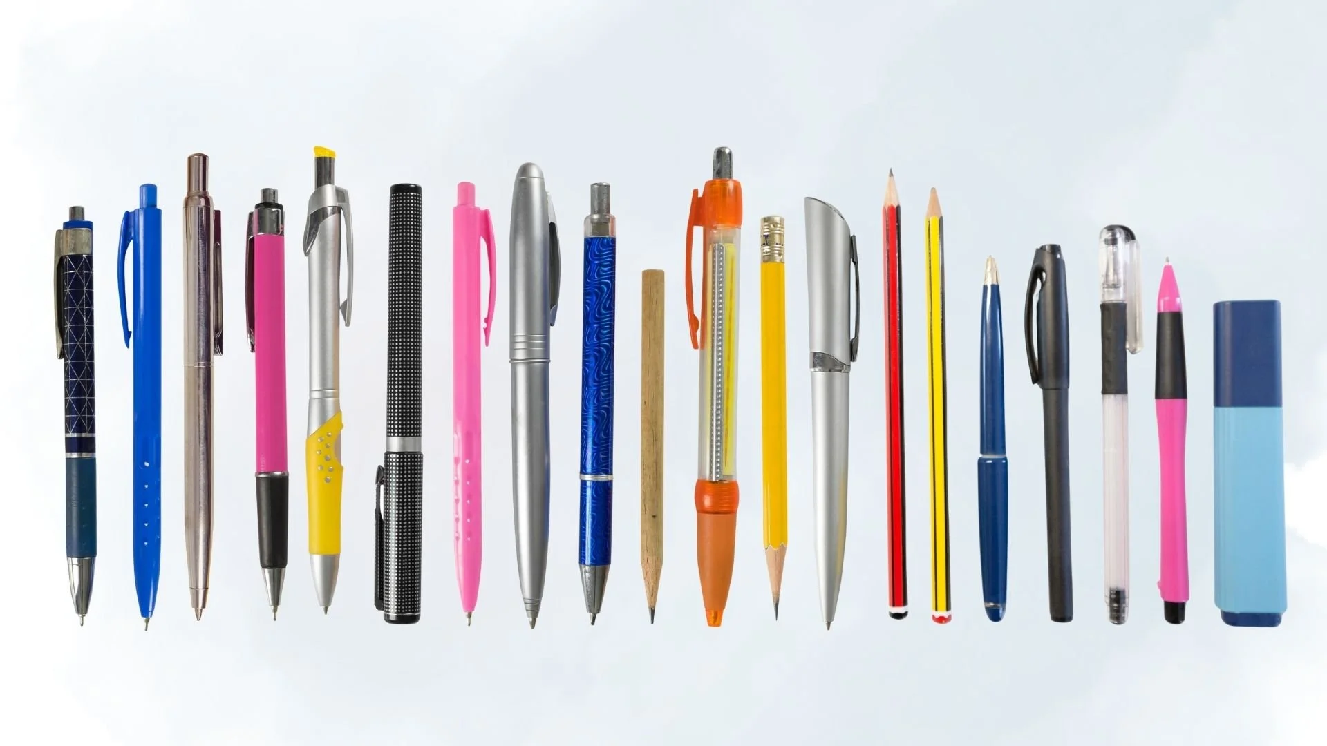 Various writing implements, including pens, pencils, and markers lined up in a row