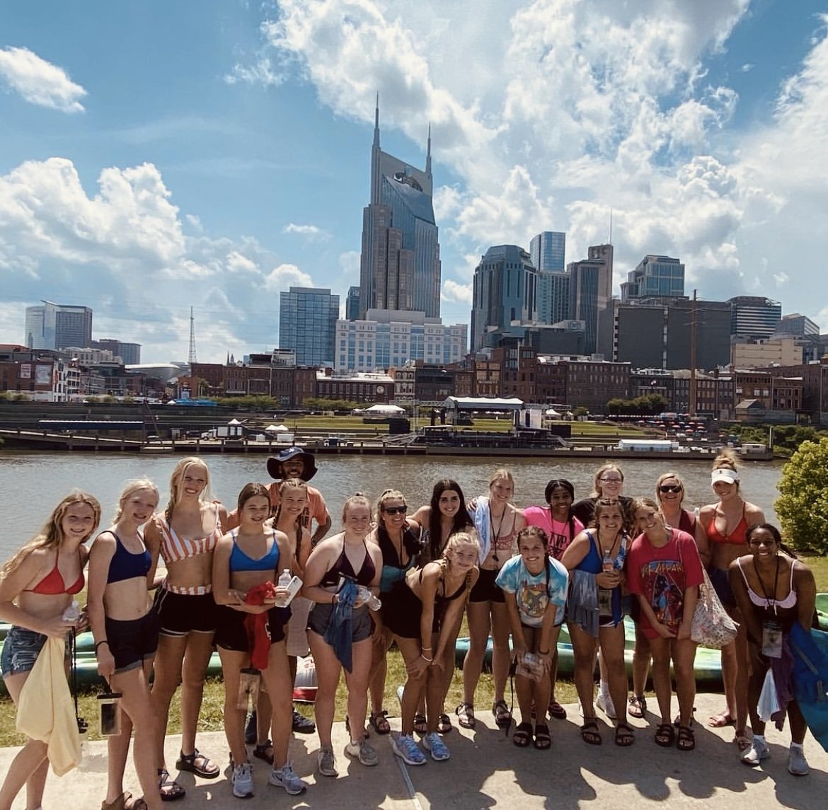 a group of women pose in front of the cumberland river and nashville skyline while enjoying River Day team building with river queen voyages