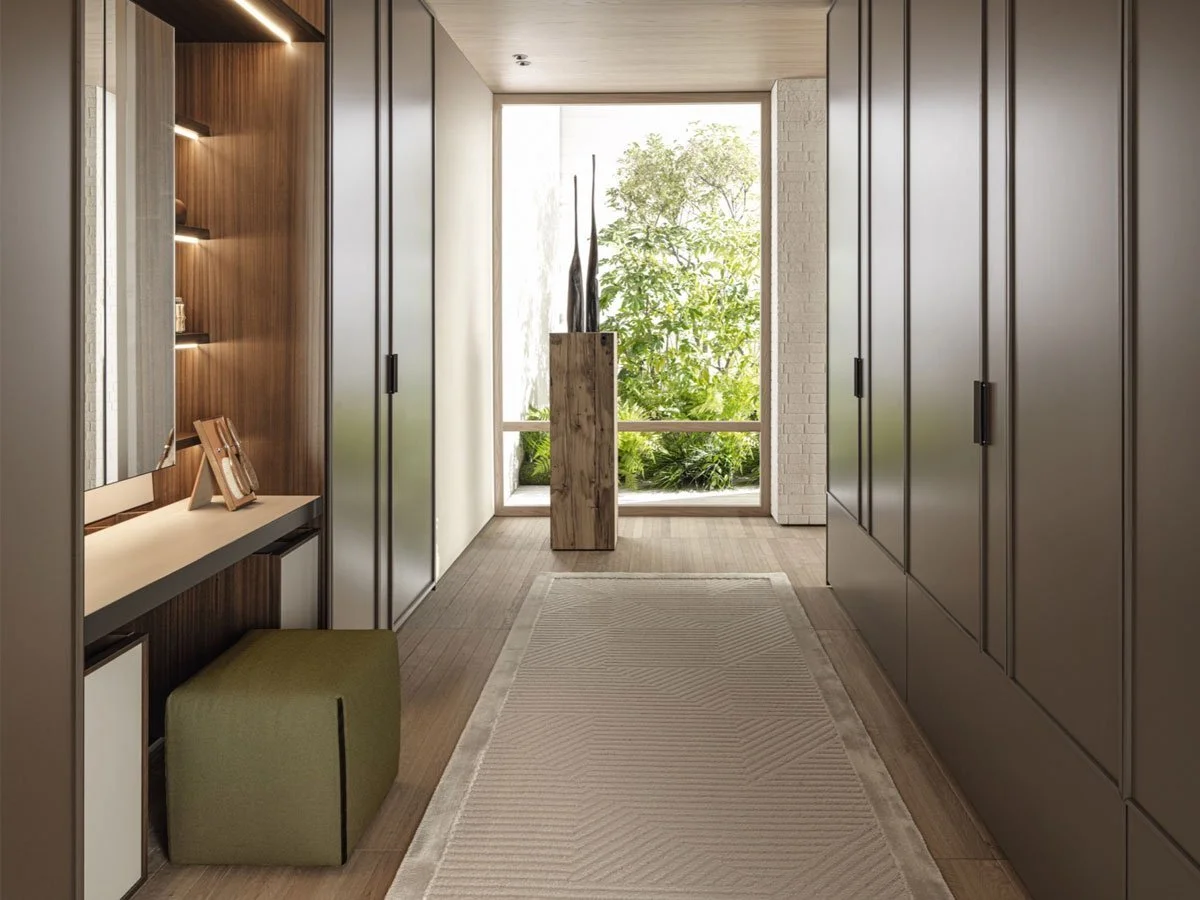 Een modern interieur met wandkasten, een smalle bank en een decoratieve houten standaard met vazen voor een grote raam met uitzicht op groen tuin.