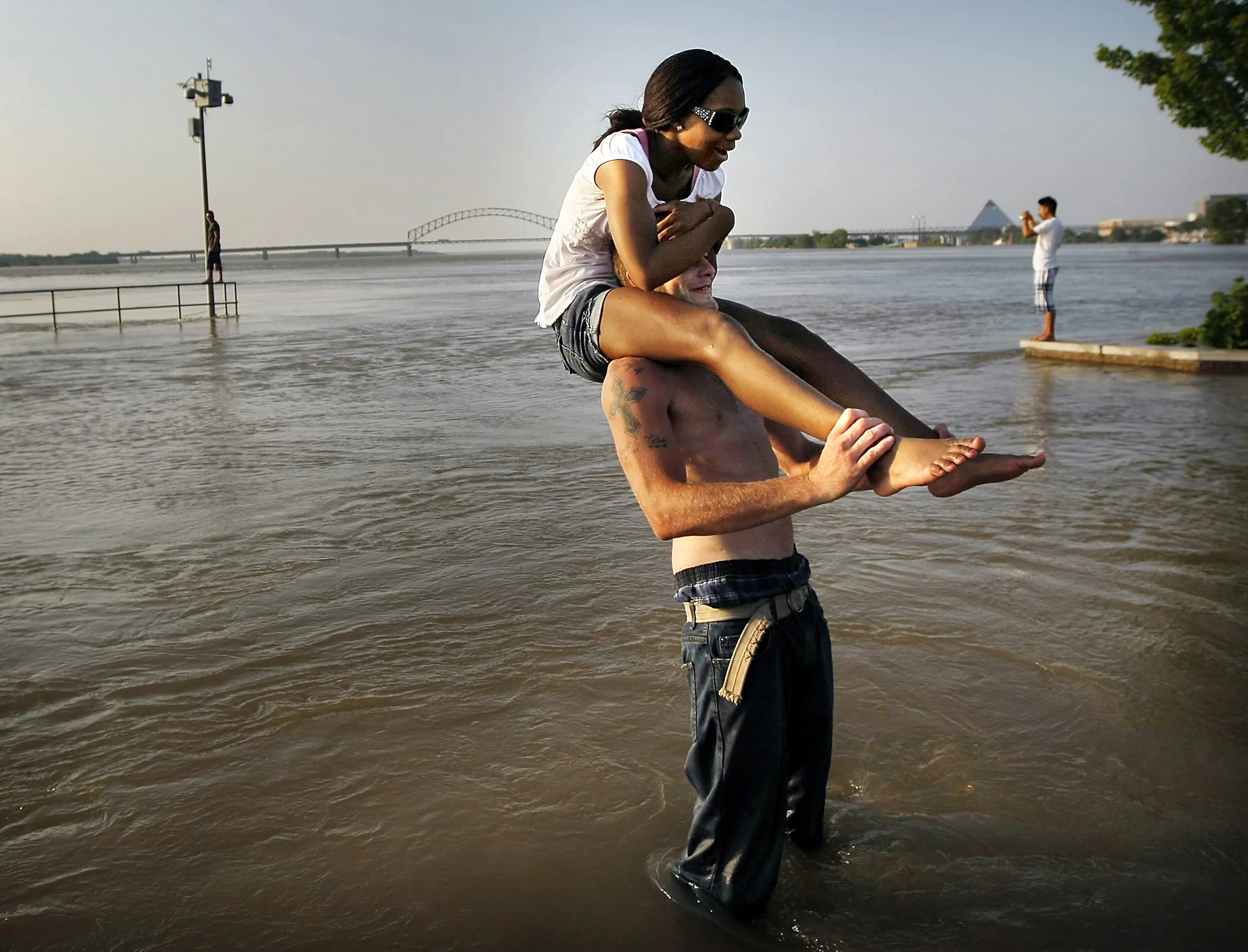  Mike Lippert threatens to dunk a skittish Lindsey Bass while the pair mess around in the flood water at Tom Lee Park and the sun sets over the swelling Mississippi river. 