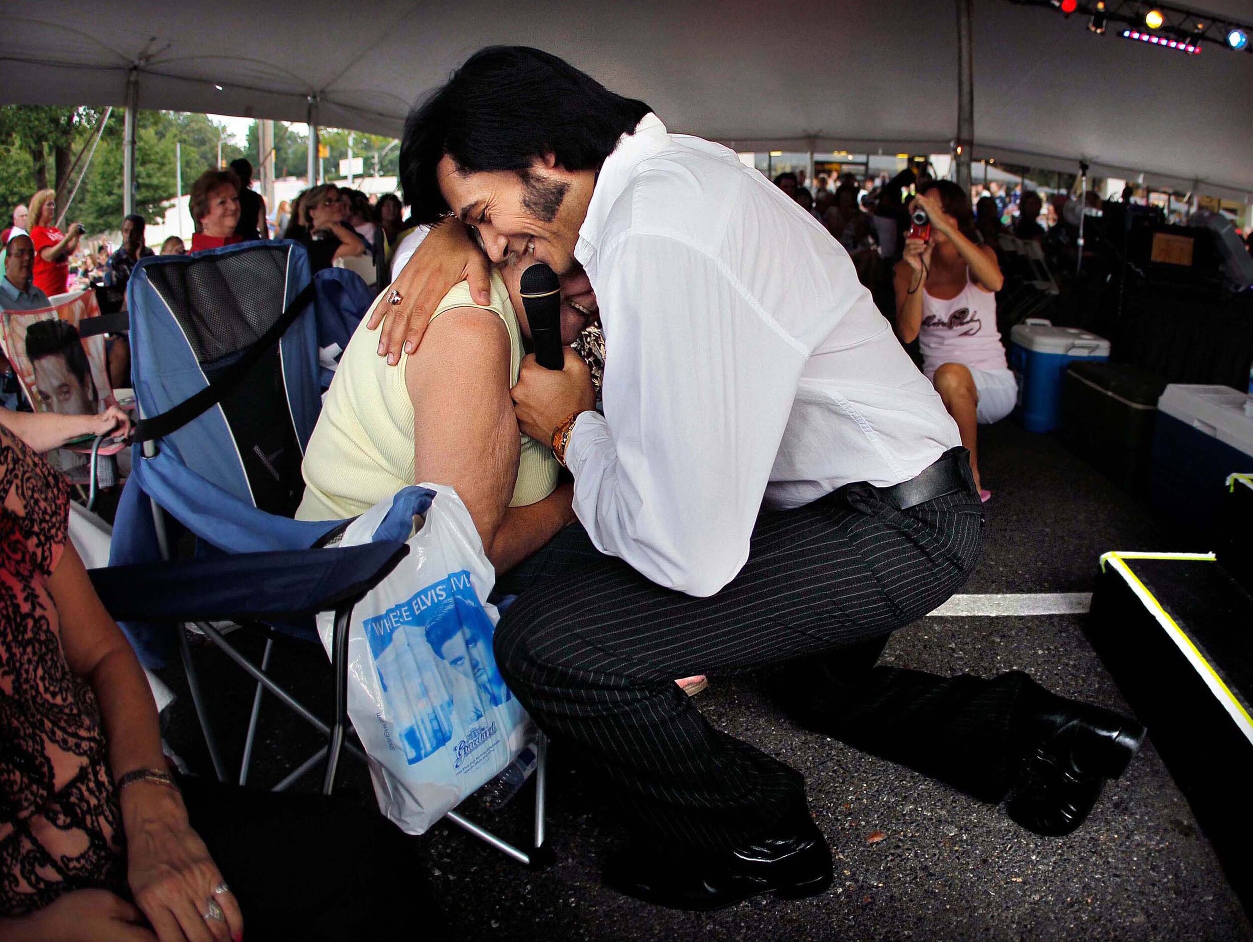   Elvis tribute artist Marcos Santos gives a personal serenade to Louise Smith of Southaven, Miss., during a performance in the Graceland Entertainment Pavilion before a vigil marking the 34th anniversary of the death of Elvis Presley Monday night. 