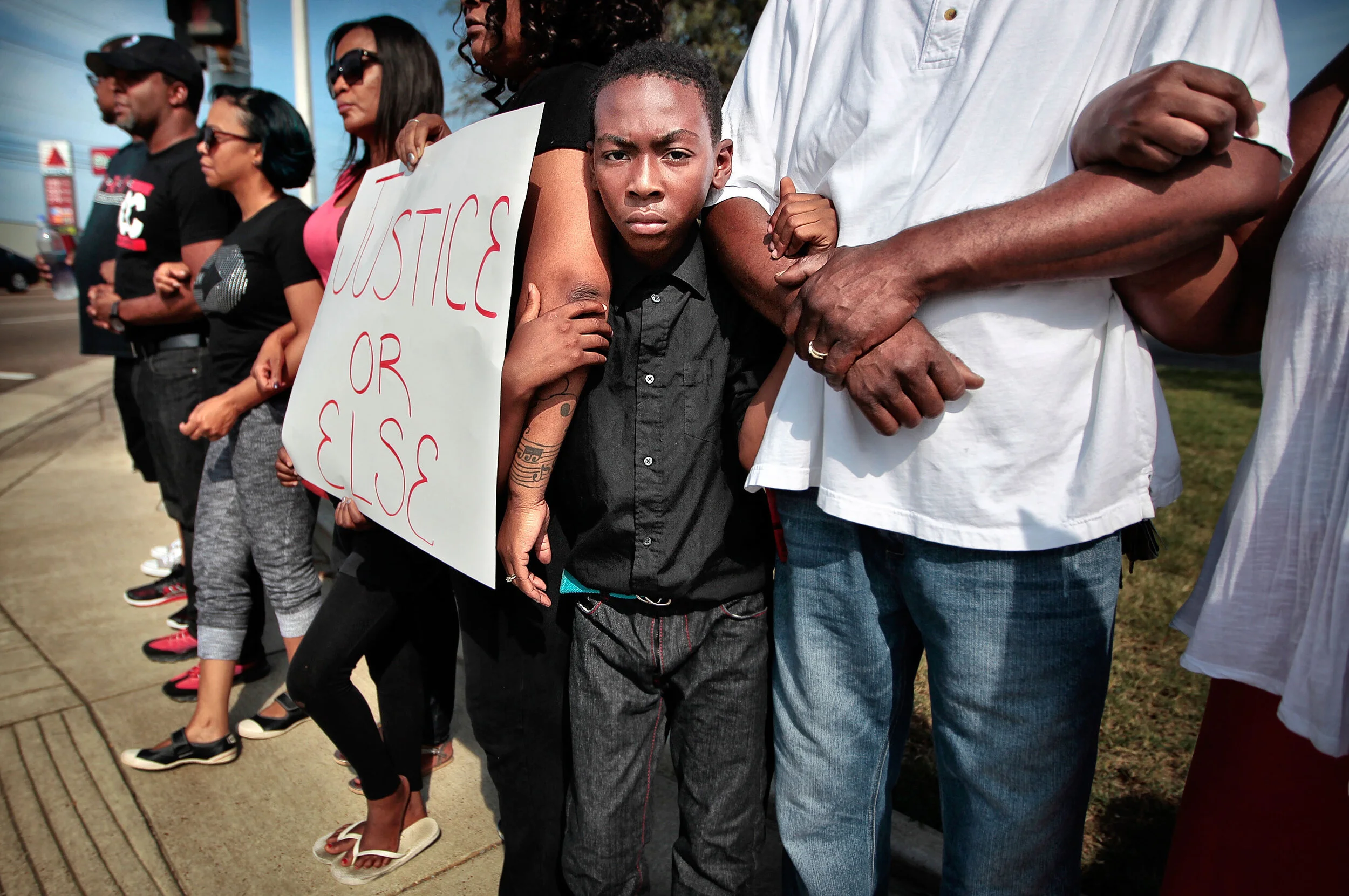  Isaiah Simpson, 10, links arms with a group of some 40 demonstrators for a few minutes of silence during a Black Lives Matter rally at the corner of Winchester and Hickory Hill where an MPD officer shot Darrius Stewart less than a month ago. Members