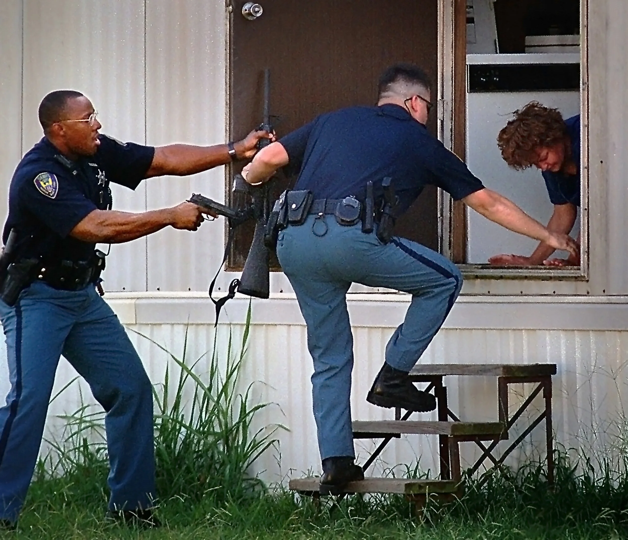  Madison County Sheriff’s Department deputies William Futrell, left, and Chad Lowery rush the residence of suspected assailant Sharon Leigh Williams after Williams shot Ernest Ray Ruminer and herself during an aggravated domestic assault Thursday aft