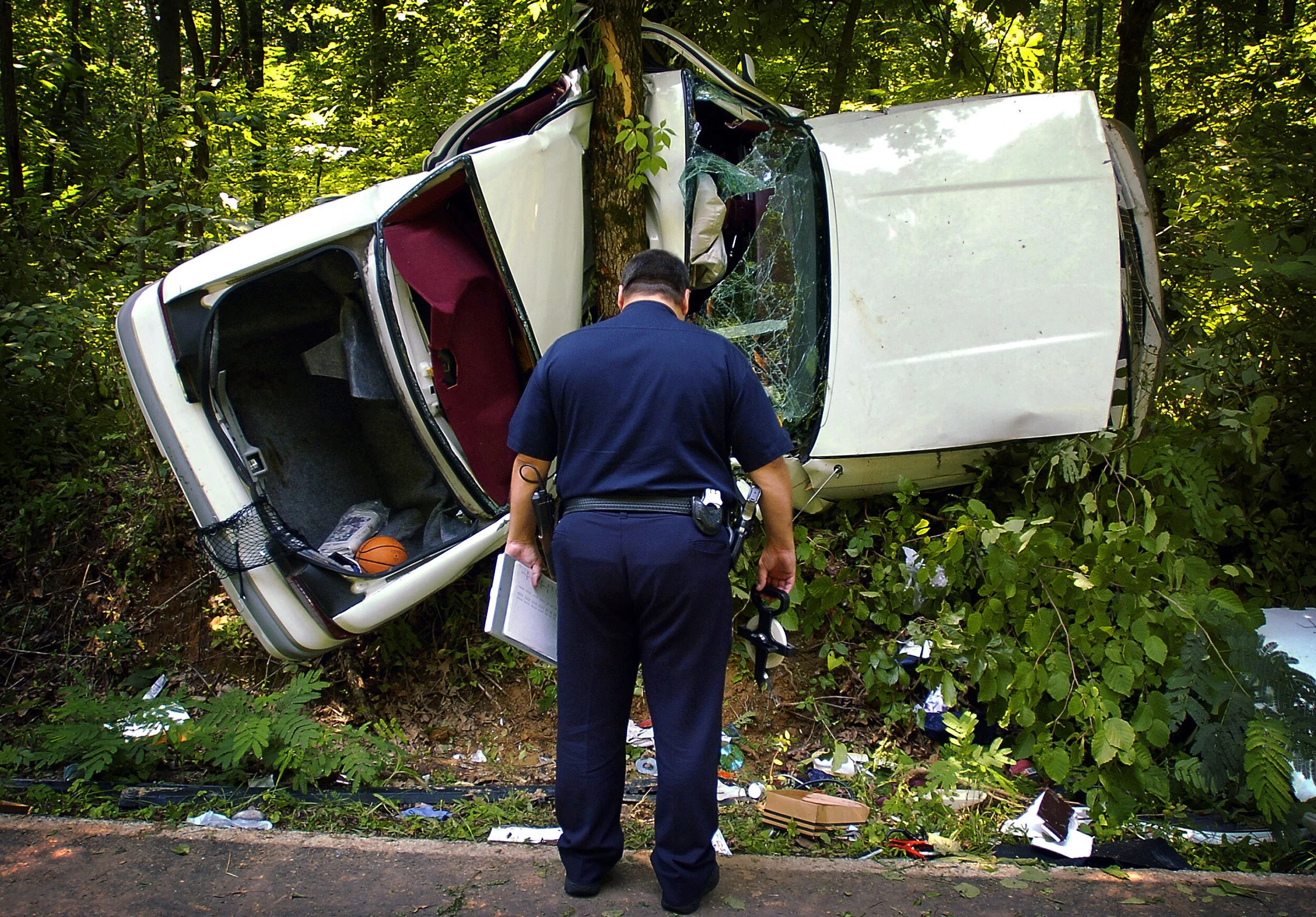  Memphis Police Sgt. Greg Hudgens investigates the scene of a one-car accident on Old Coleman Road in Frayser after the driver lost control and wedged his car behind a tree Monday afternoon. Officials at the scene said the driver had to be removed fr