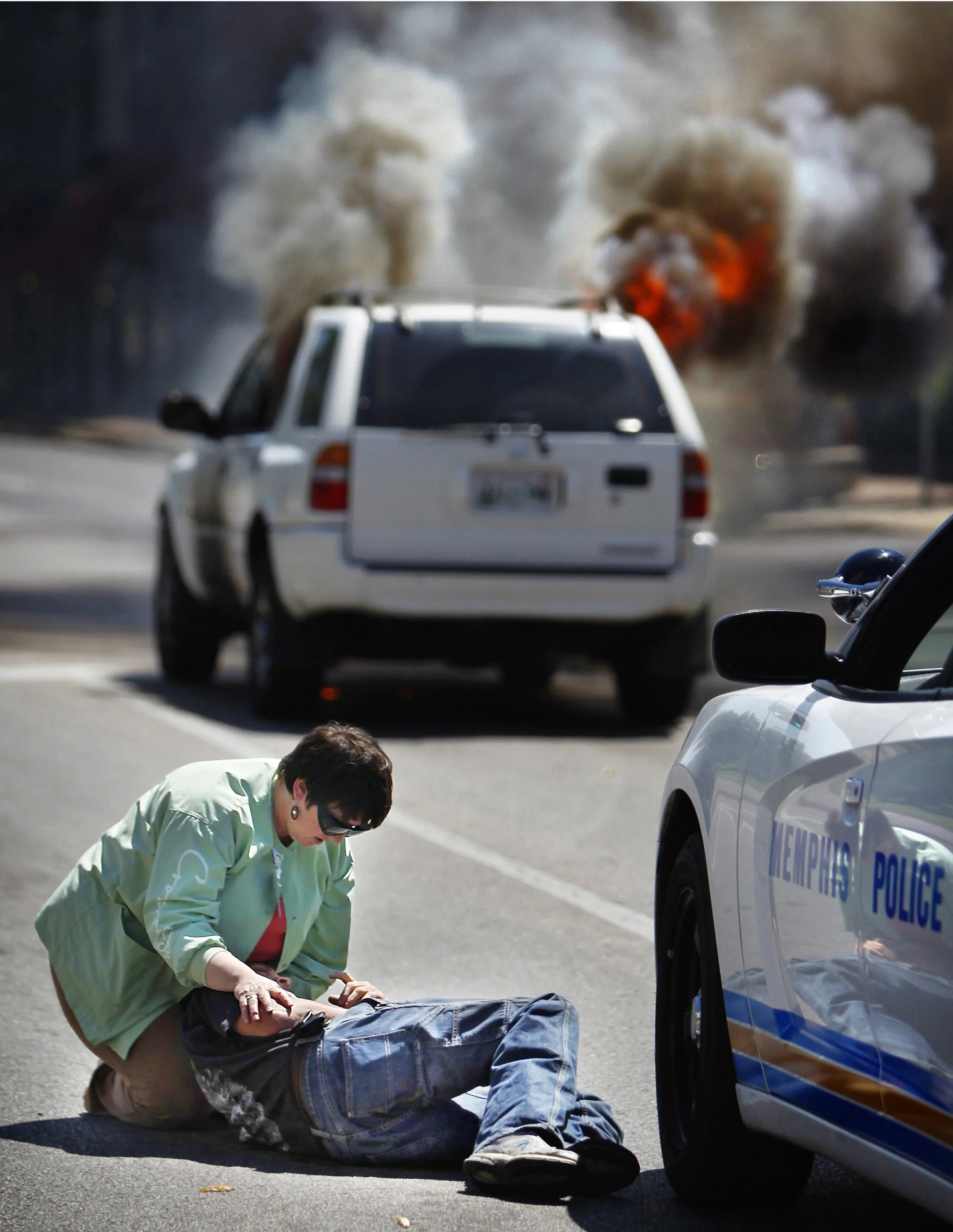  Hospice nurse Lynn Packard aids Chris Scott after his car caught fire Tuesday near Overton Park. Memphis Police Officer K. Barrett and another bystander, Richard Johnston, quickly pulled Scott away from the smoking car before firefighters arrived to