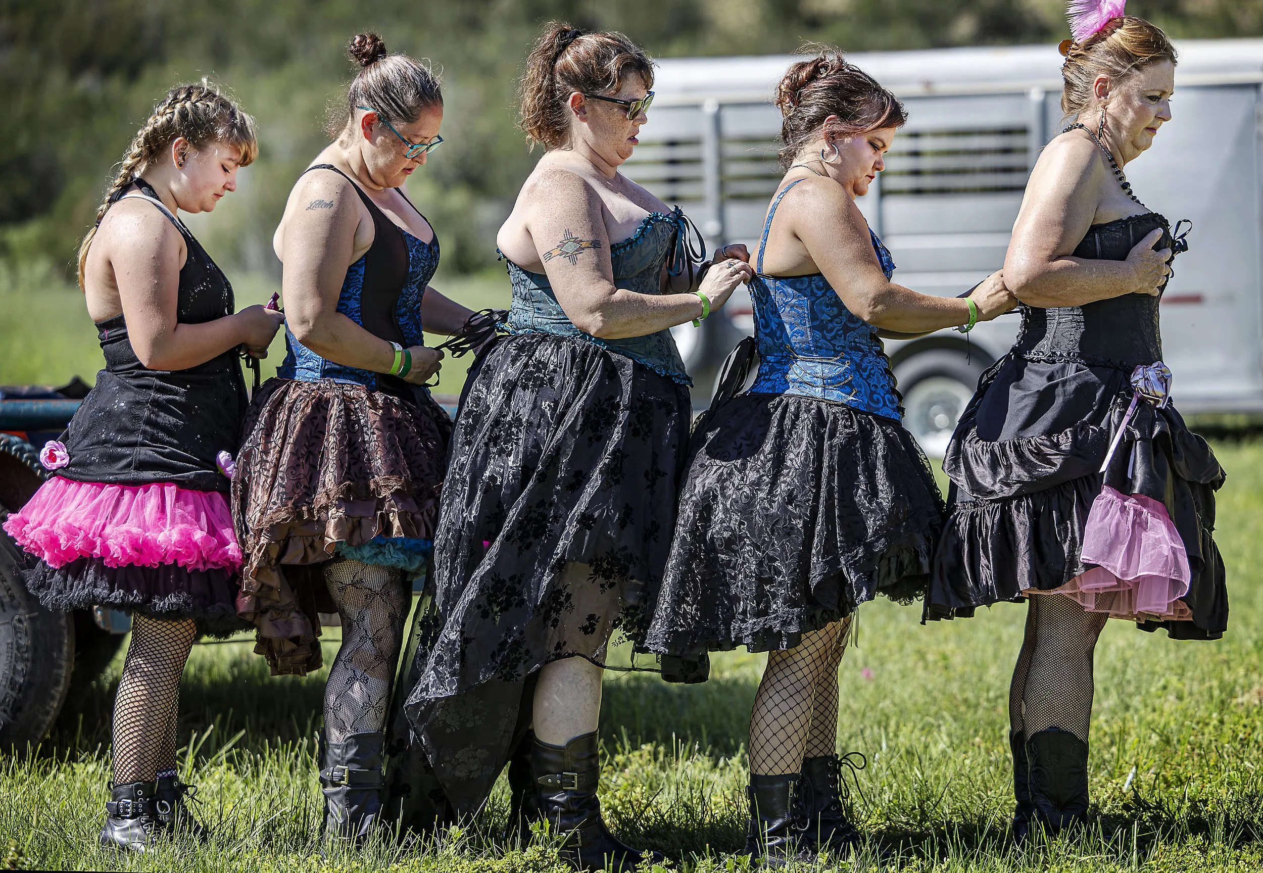  Pageant cast members Arya Nowell, left, Kristy Silva, Dusty Rushing Shana Nowell and Laura Wilson help each other out with corset adjustments before the start of the old Lincoln Days parade in Lincoln, NM on Sunday Aug. 3, 2025, featuring a Billy Th