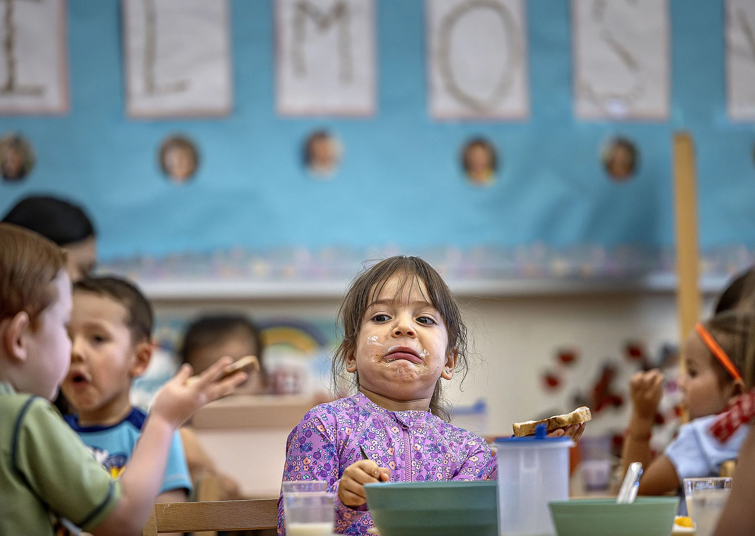  Evelyn Berrera, center, reacts to her classmate's dubious breakfast choice as she eats toast slathered in yogurt and peaches during the morning meal in Randy Orona's Pre-K class on Thursday, June 12, 2025 at SFCC's Kids Campus. A recent study presen