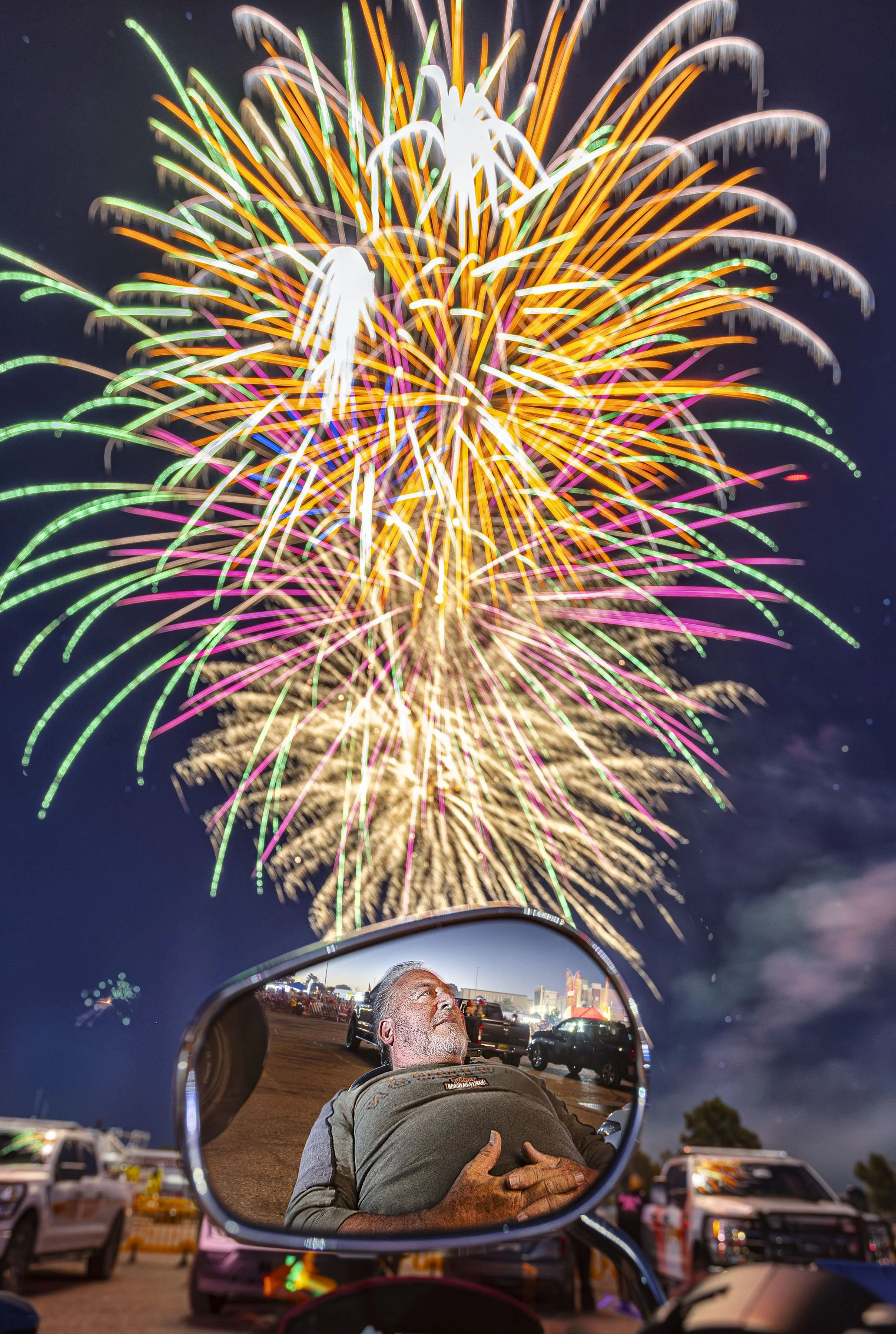  Reflected in his motorcycle's mirror, retired Santa Fe Battalion Chief Ed Rael leans back and watches the show during the annual Fourth of July Fireworks display at the Santa Fe Place Mall on Thursday, July 4, 2024  hosted by the Kiwanis Club of San