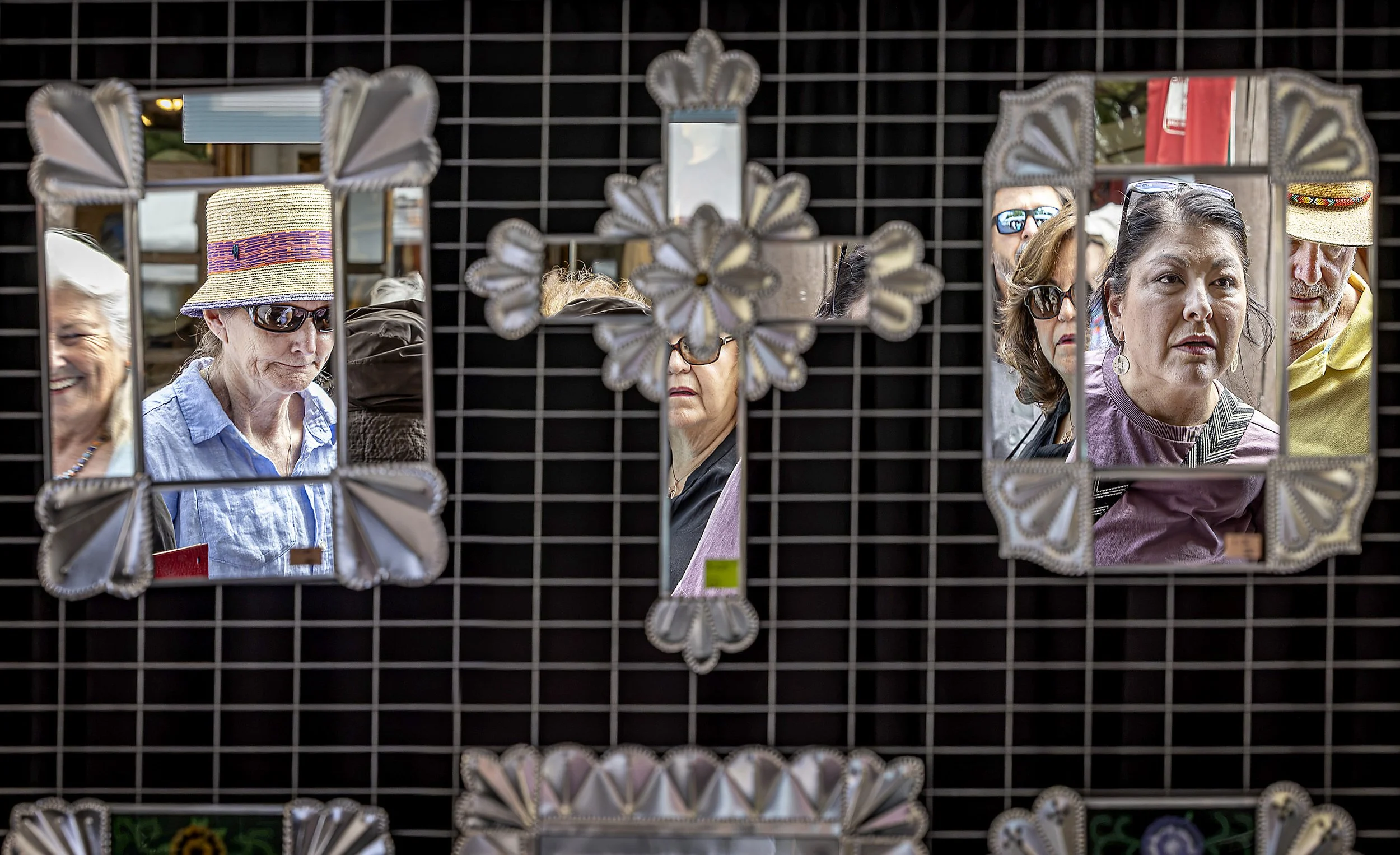  Marketgoers crowd around tinwork artist Cleo Romero's booth during the 74th Traditional Spanish Market and the Contemporary Spanish Market in Santa Fe on Saturday, July 25, 2026. This year marks 100 years since the first Traditional Spanish Market o