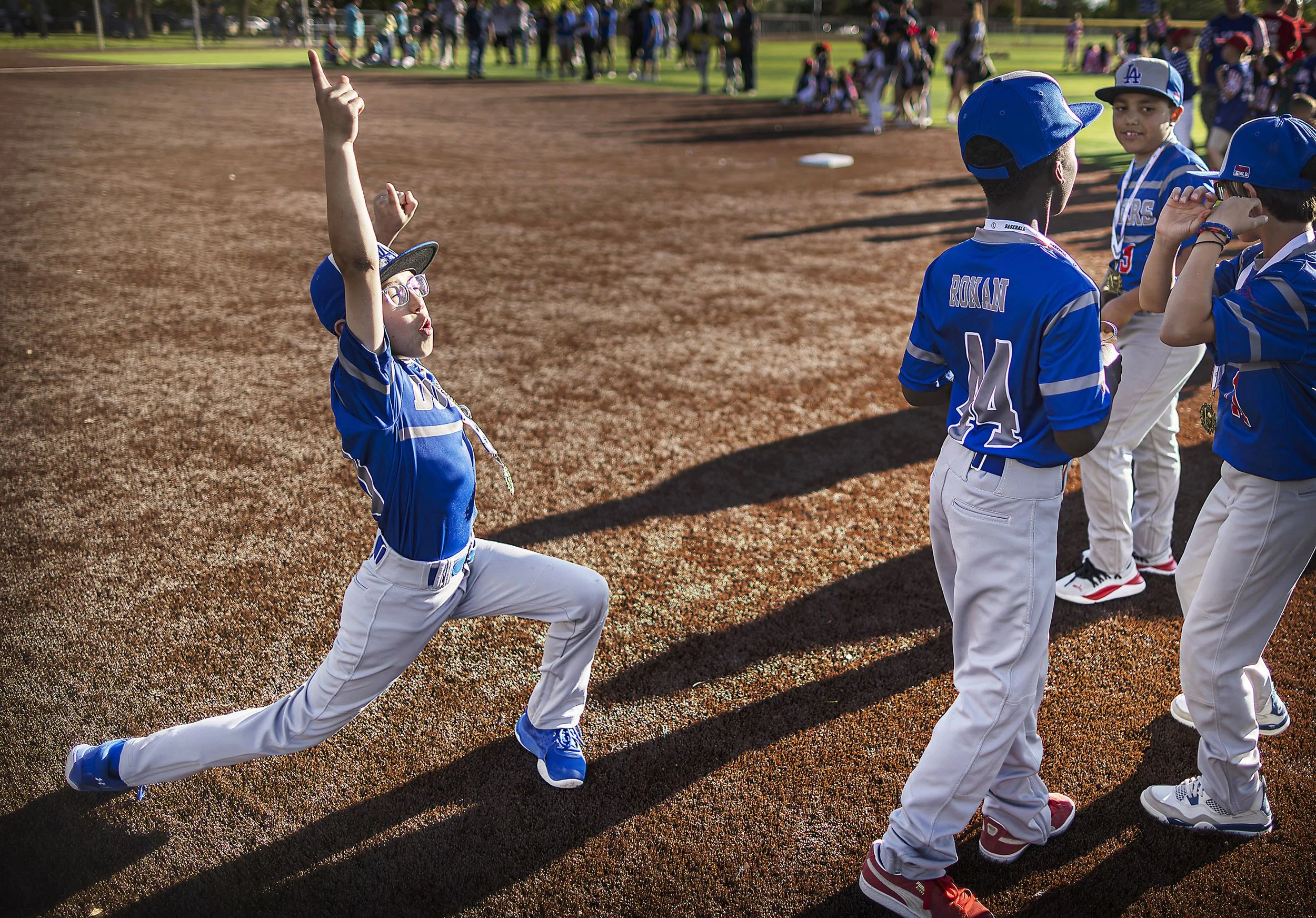  The Dodgers' Bubba Ortega, left, celebrates with the rest of the team after finishing first place in the 8-10 year old Majors Division as teams gather on the field during the closing festivities for the Santa Fe Little League season at Ragle Park on