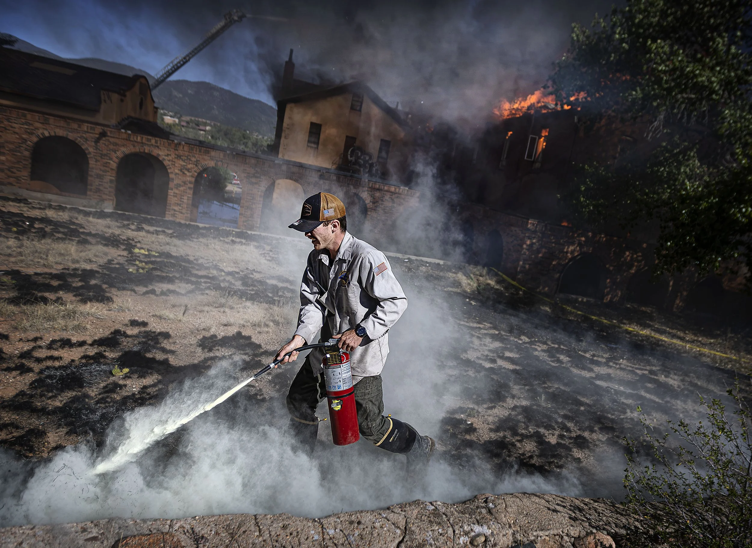  National Cemetery staff member Miles Malone puts out grass fires as City firefighters battle a blaze for hours on Thursday, July 2, 2026, at the historic campus of the former St. Catherine Indian School. 