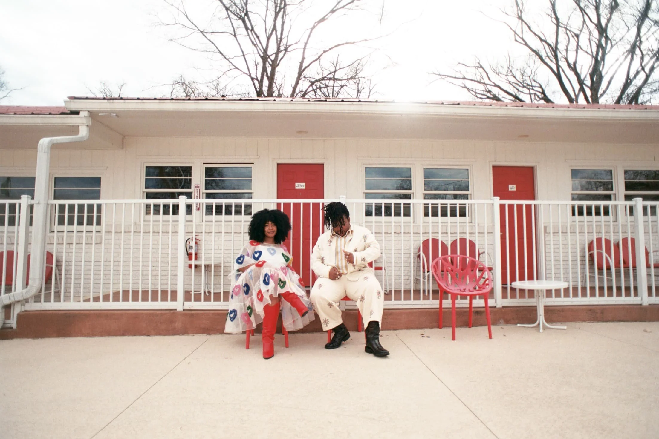 lesbian couple sitting outside of a vintage motel in nashville tn on their wedding day at the dive motel 