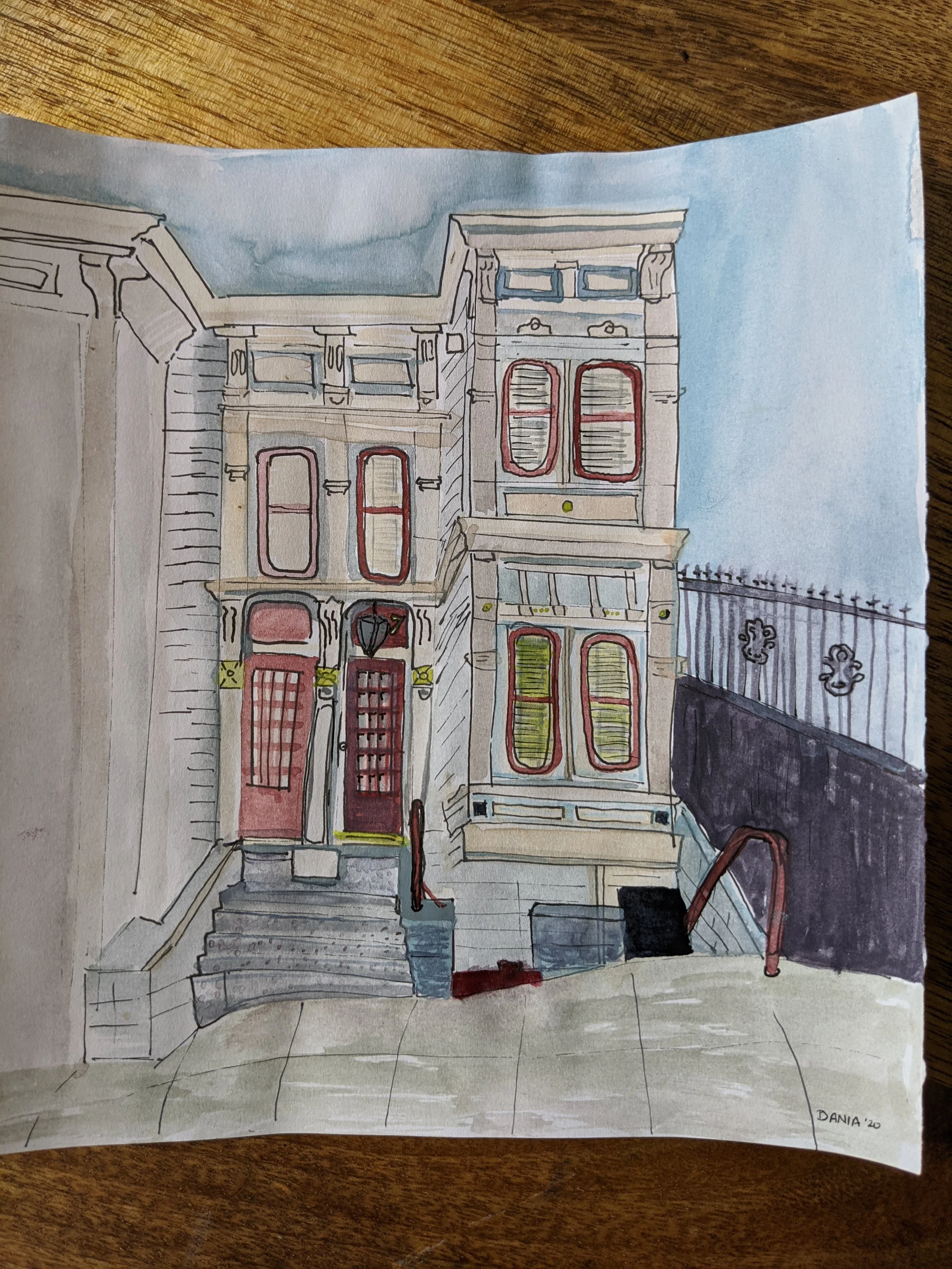 Colorful watercolor sketch of a vintage brownstone building with red accents and a staircase leading up to the front door, positioned on a corner with a sidewalk.