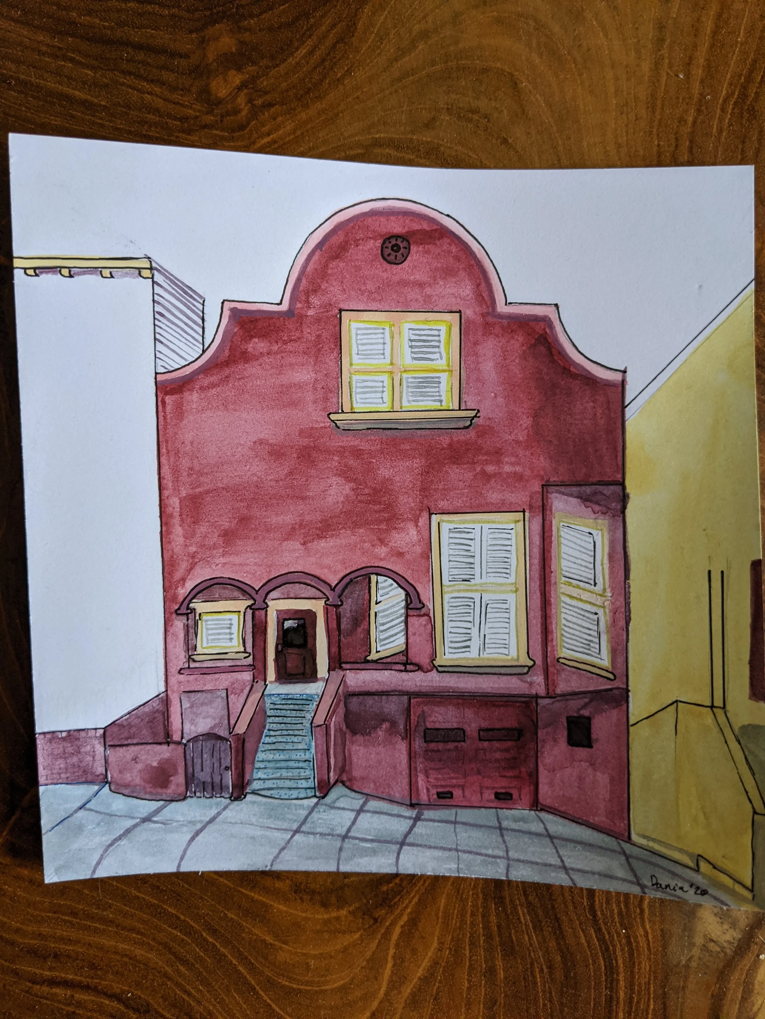 A watercolor painting of a two-story house with red walls, yellow window frames, and an arched roof. The house has a front staircase, arched doorway, and a garage on the lower level. The house is depicted with some details of the sidewalk and surroun