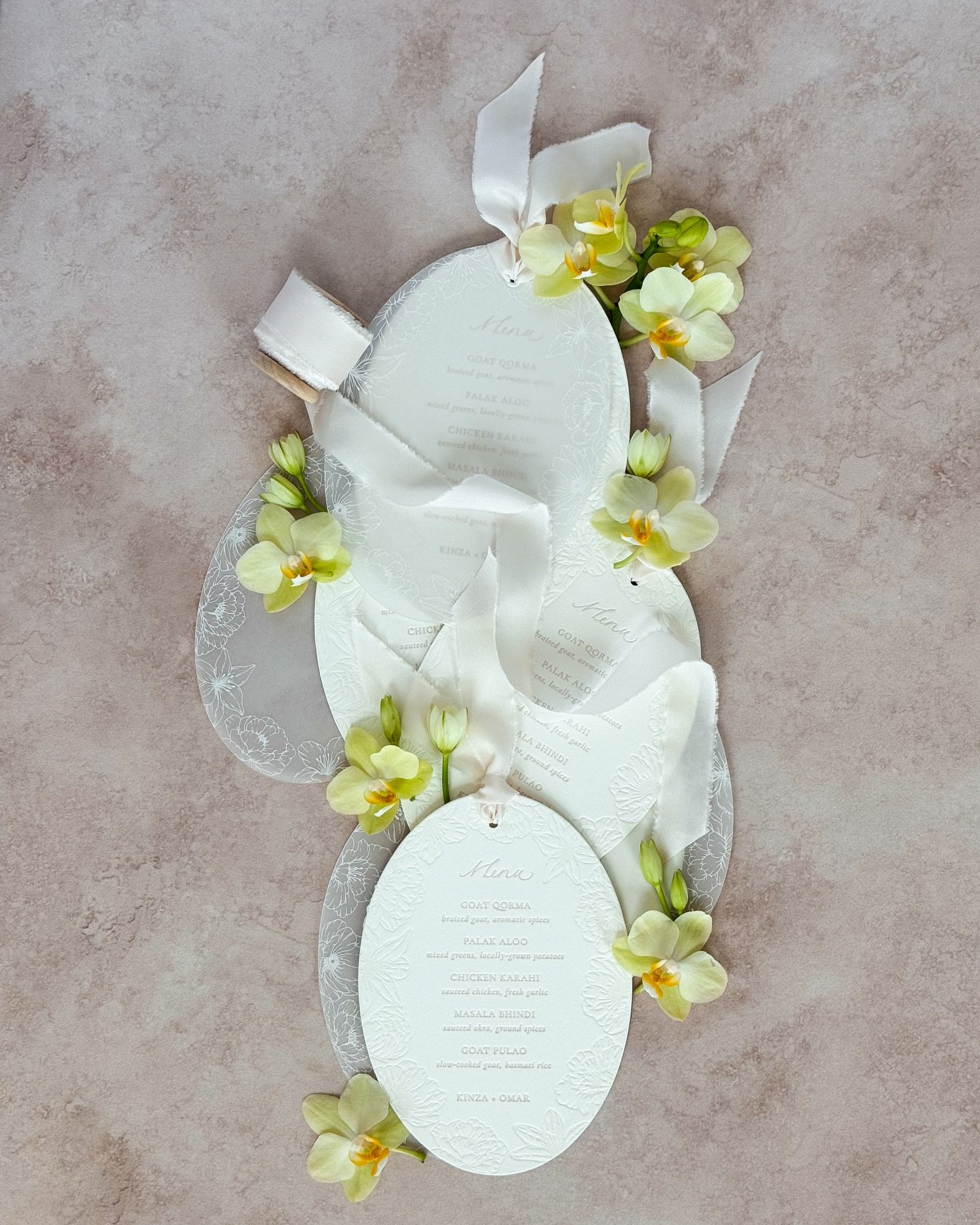 The prettiest menus for Kinza + Omar 🤍

These oval menus were printed and die cut by one of our 1912 letterpress&mdash;layered with tonal deboss florals, silk ribbon, and soft vellum.

Designed to elevate your tablescape and become a keepsake your g