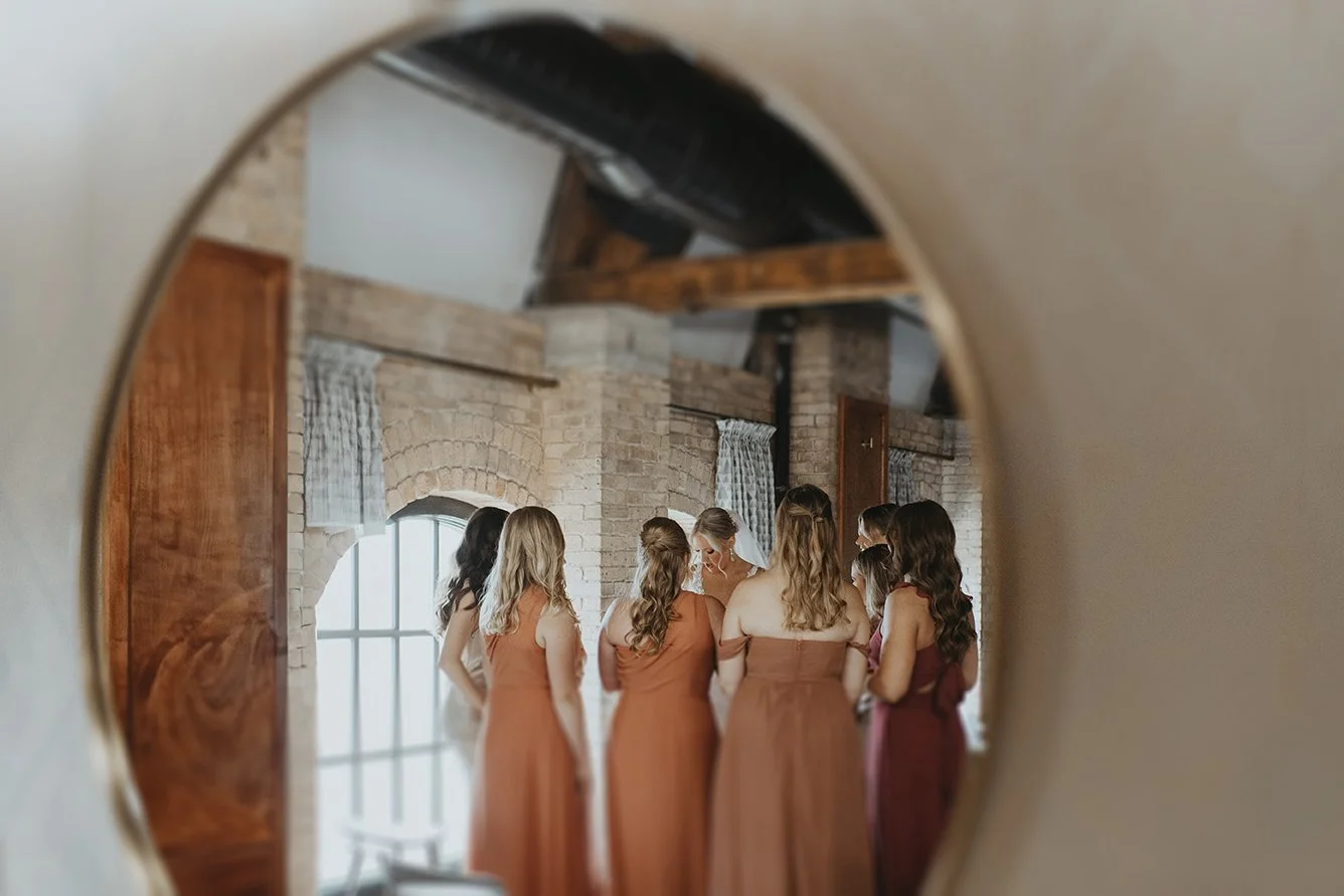 bride sharing a private moment with her bridesmaids