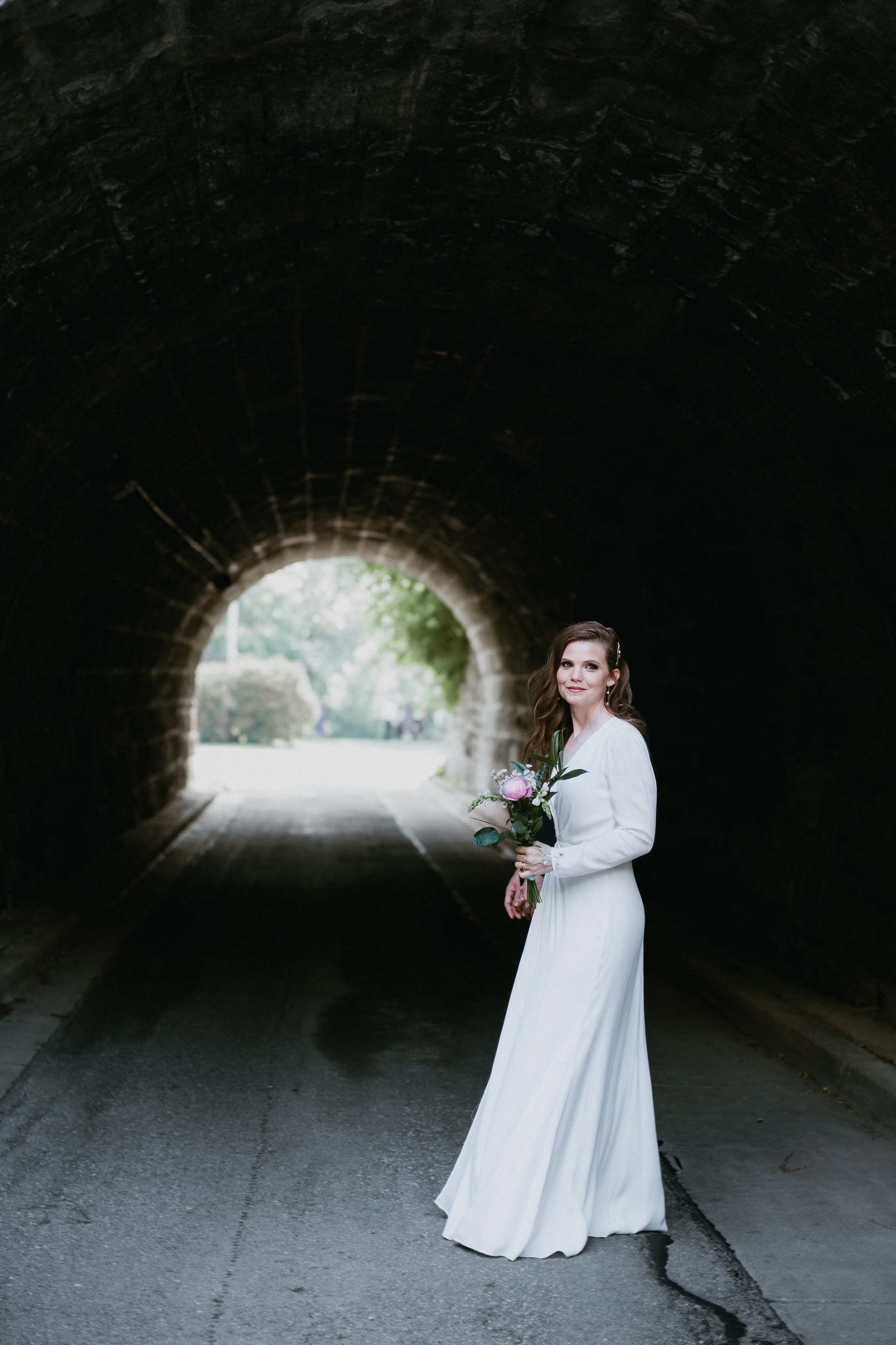 Candid Bridal portrait of bride walking down a tunnel at spring time wedding in Minnesota