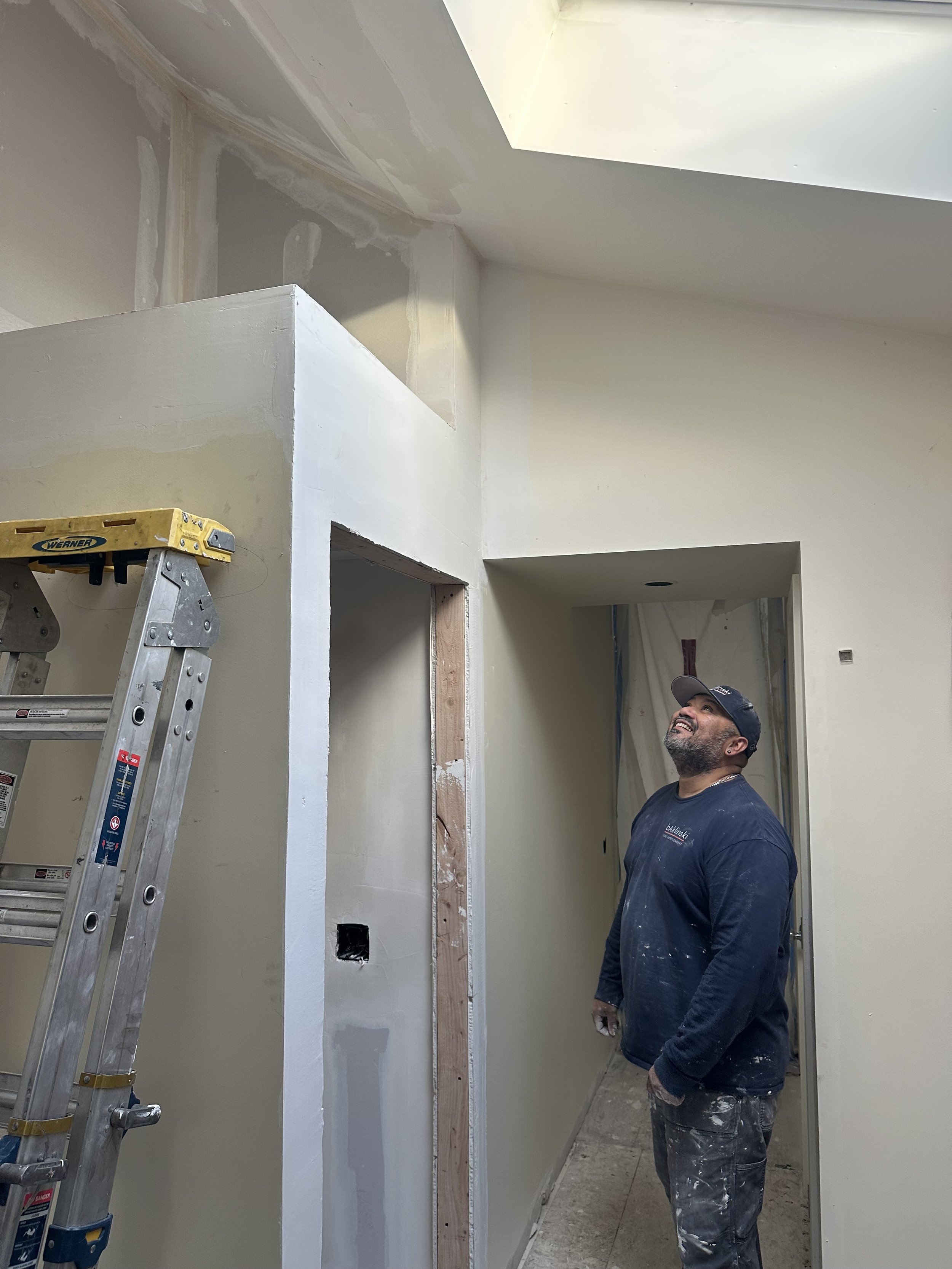 Skilled crew member Alex installing drywall during house remodel Seattle project