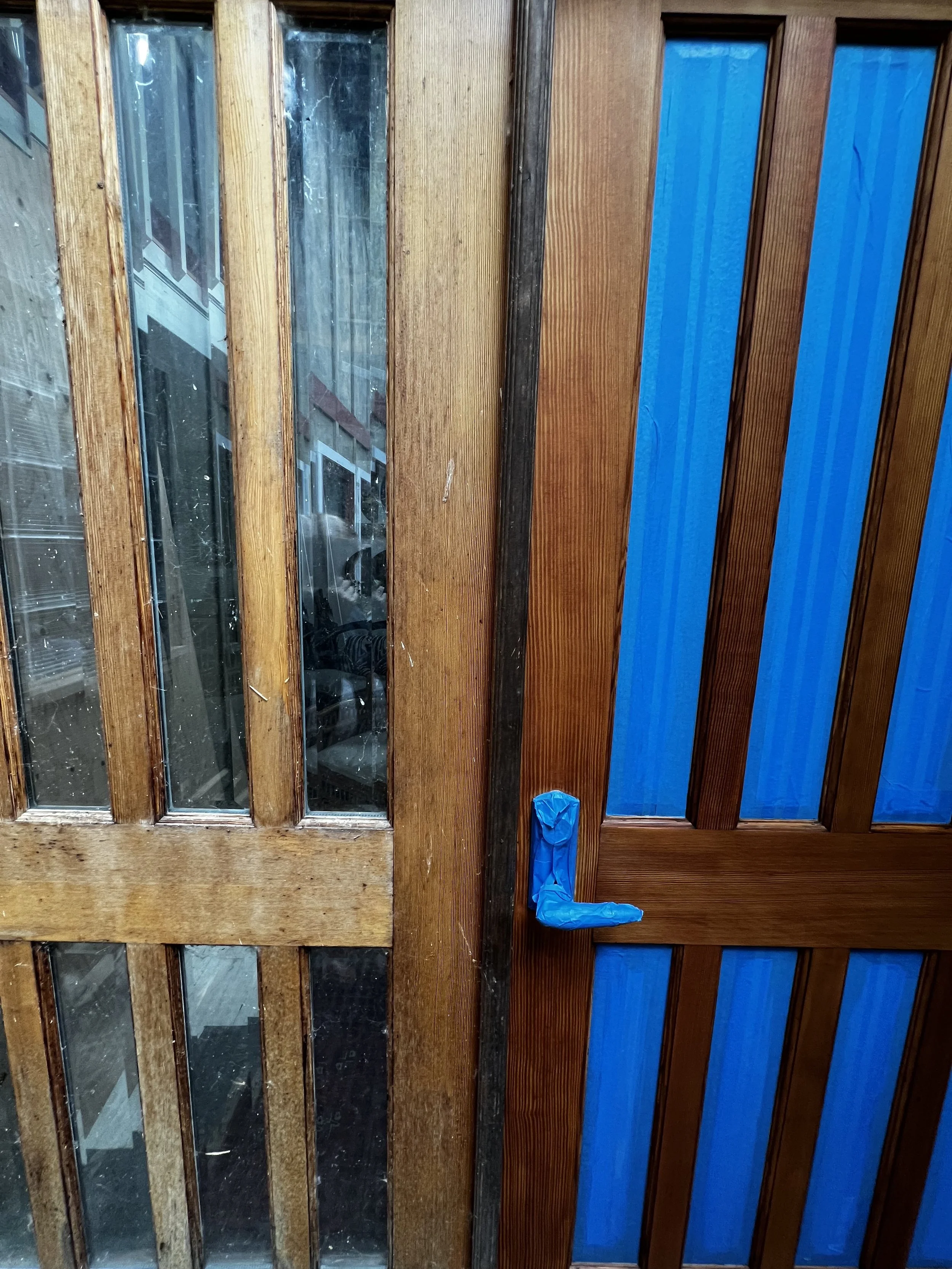 Seattle handyman performing wood door restoration on 20-year-old exterior doors with natural stain