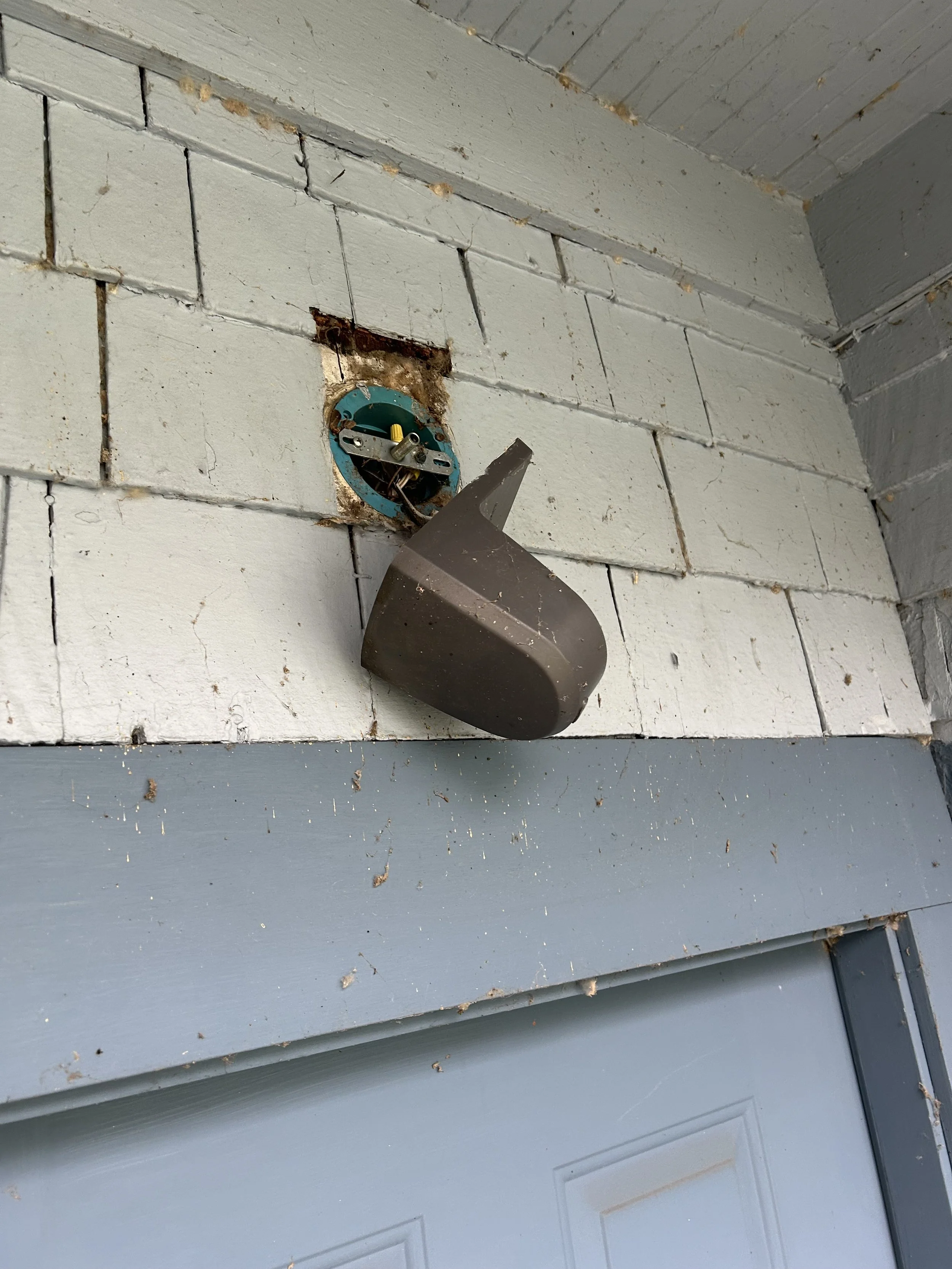 Old outdated outdoor porch light fixture on Seattle area home before replacement by Baklinski handyman services