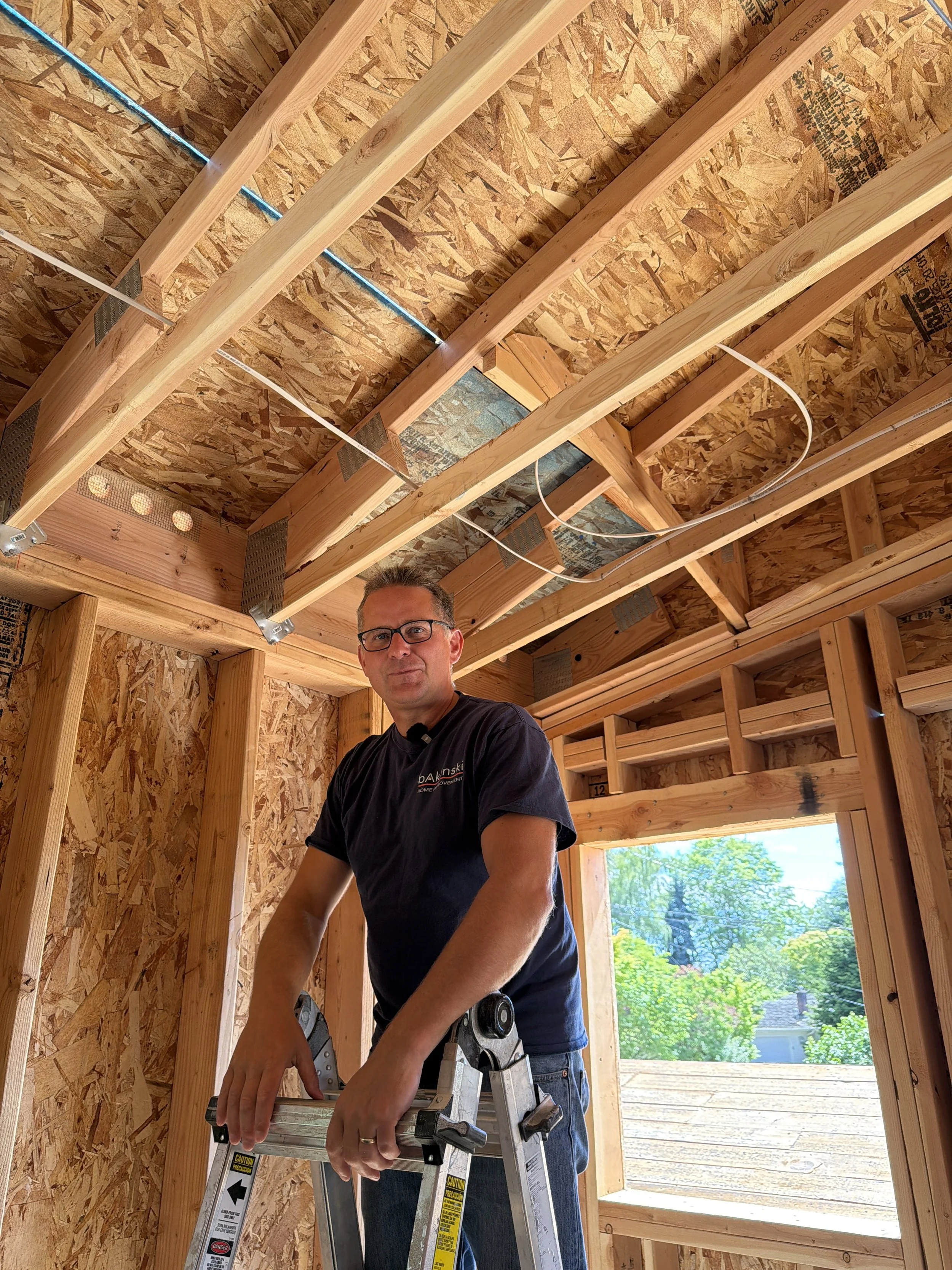 Andrew Baklinski explaining roof soffit vents on a hot Seattle day" – Caption: "Hey, it's hot out here – but your attic doesn't have to be