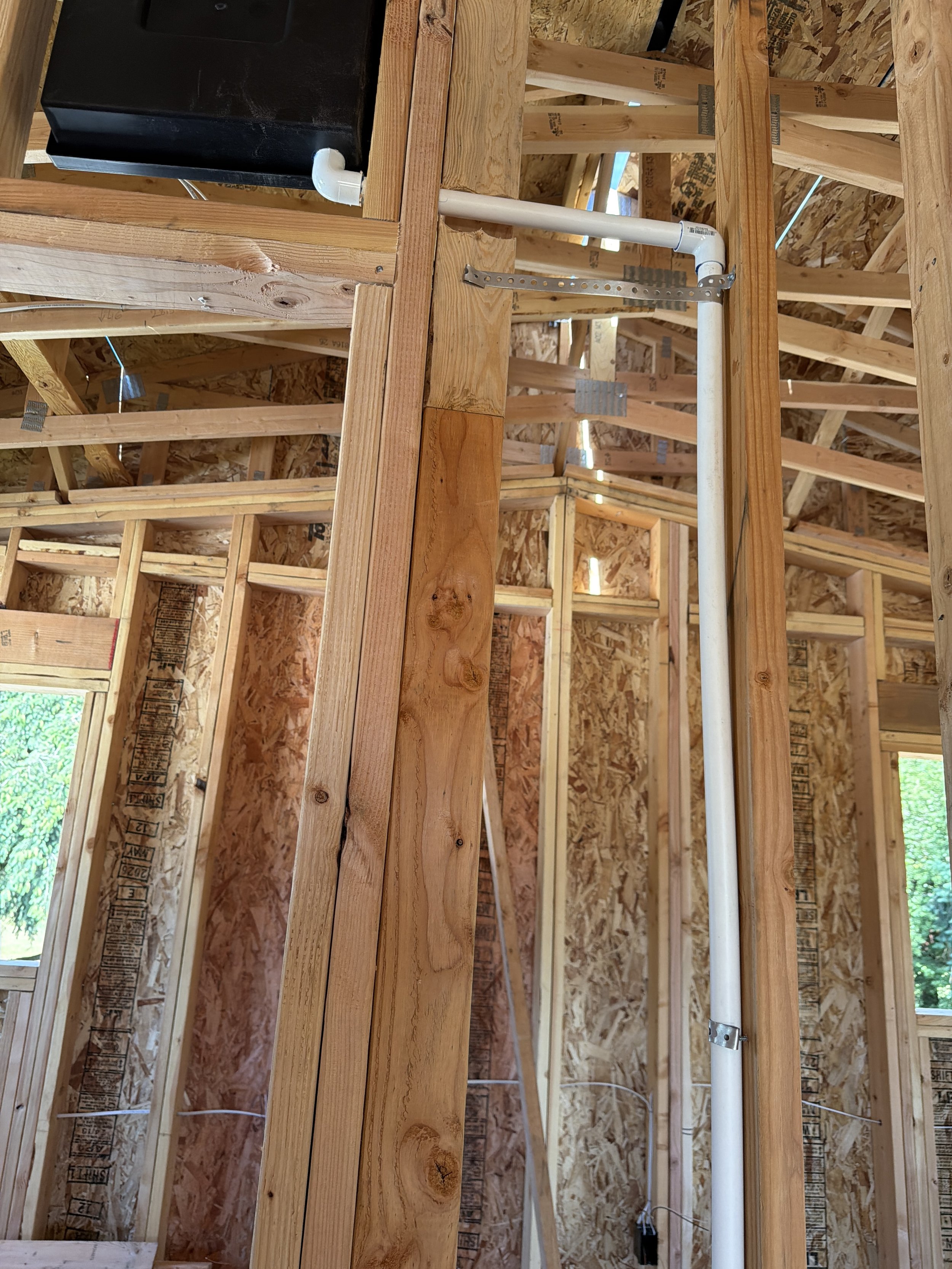 White PVC condensation drain line from cooling units in Pacific Northwest home addition