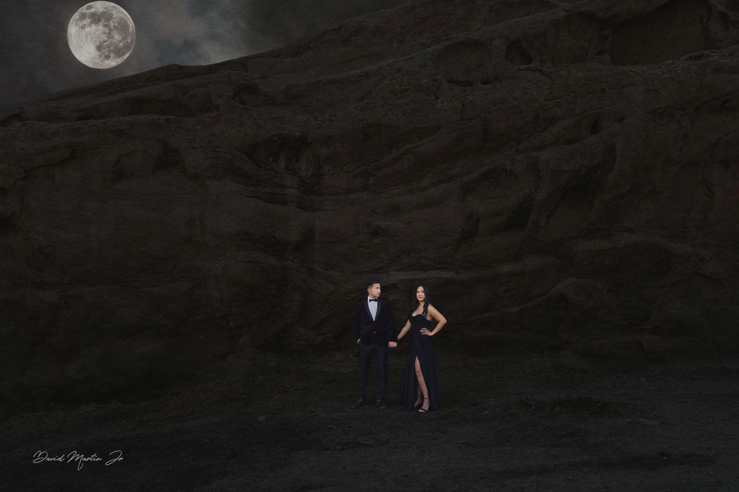 Engaged couple holding hands in the dark lit up by the moonlight at Vasquez Rocks