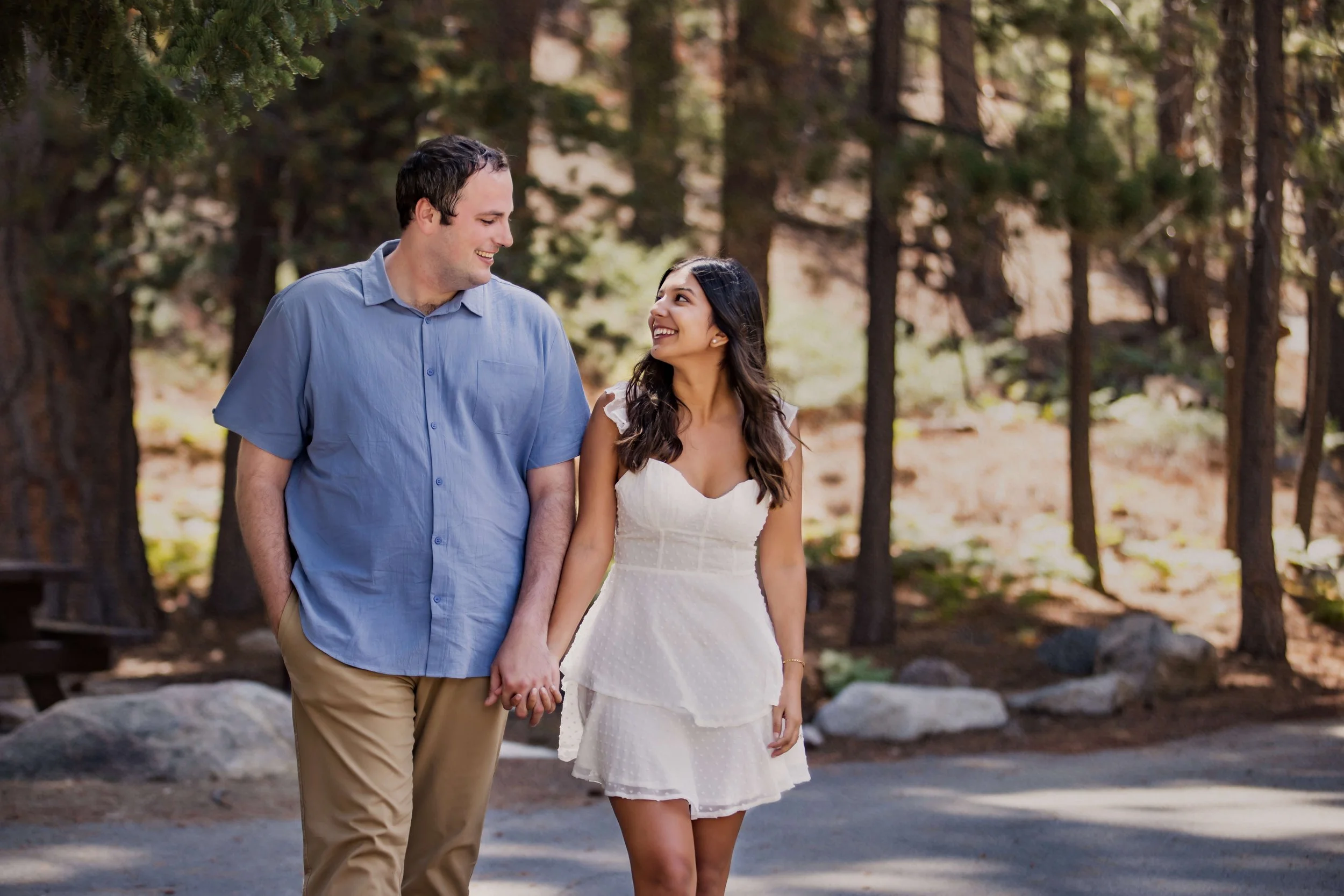 Engaged couple holding hands while walking through the Angeles National Forest