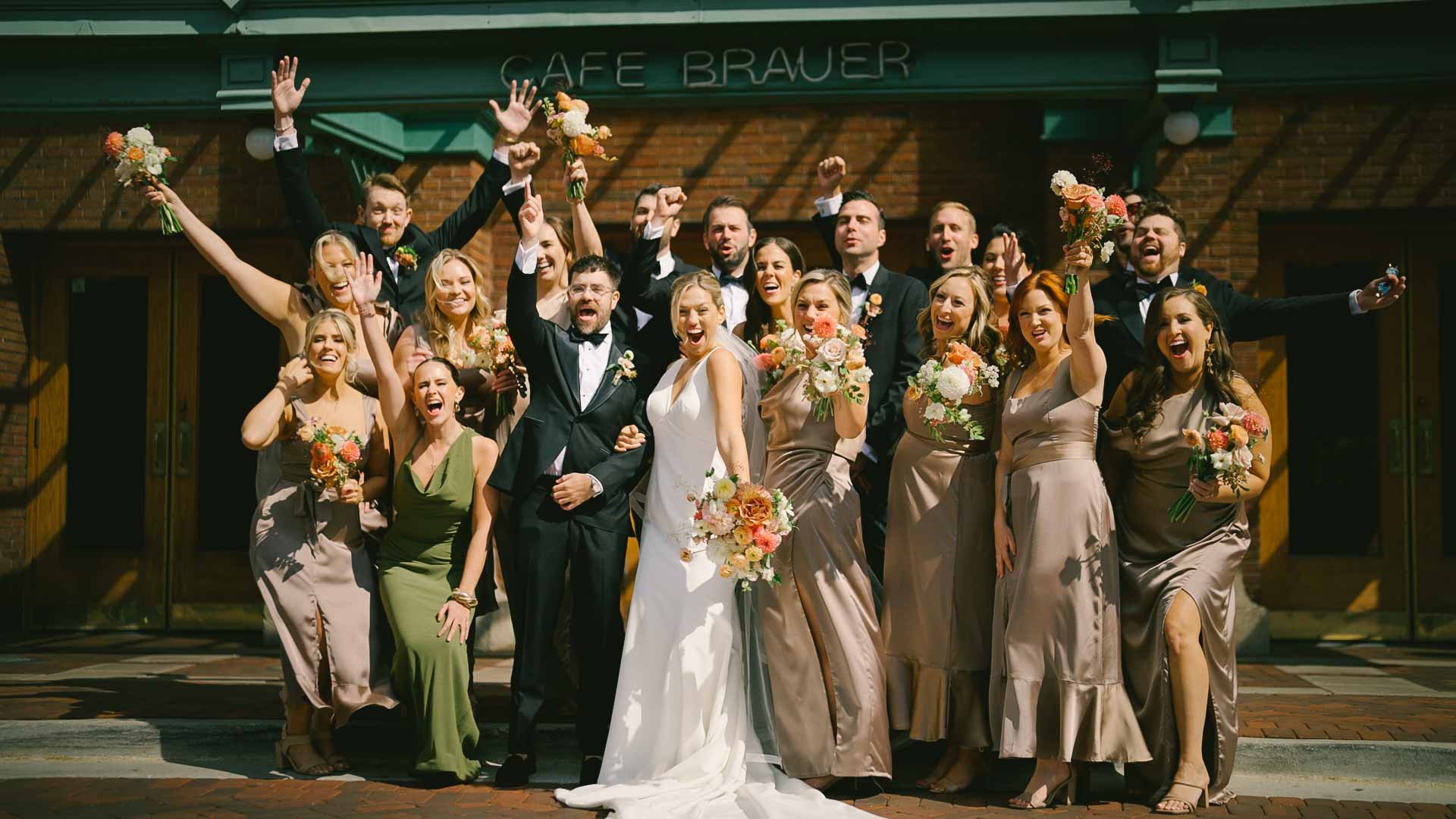 bridal party in champagne and green and black smiling and laughing