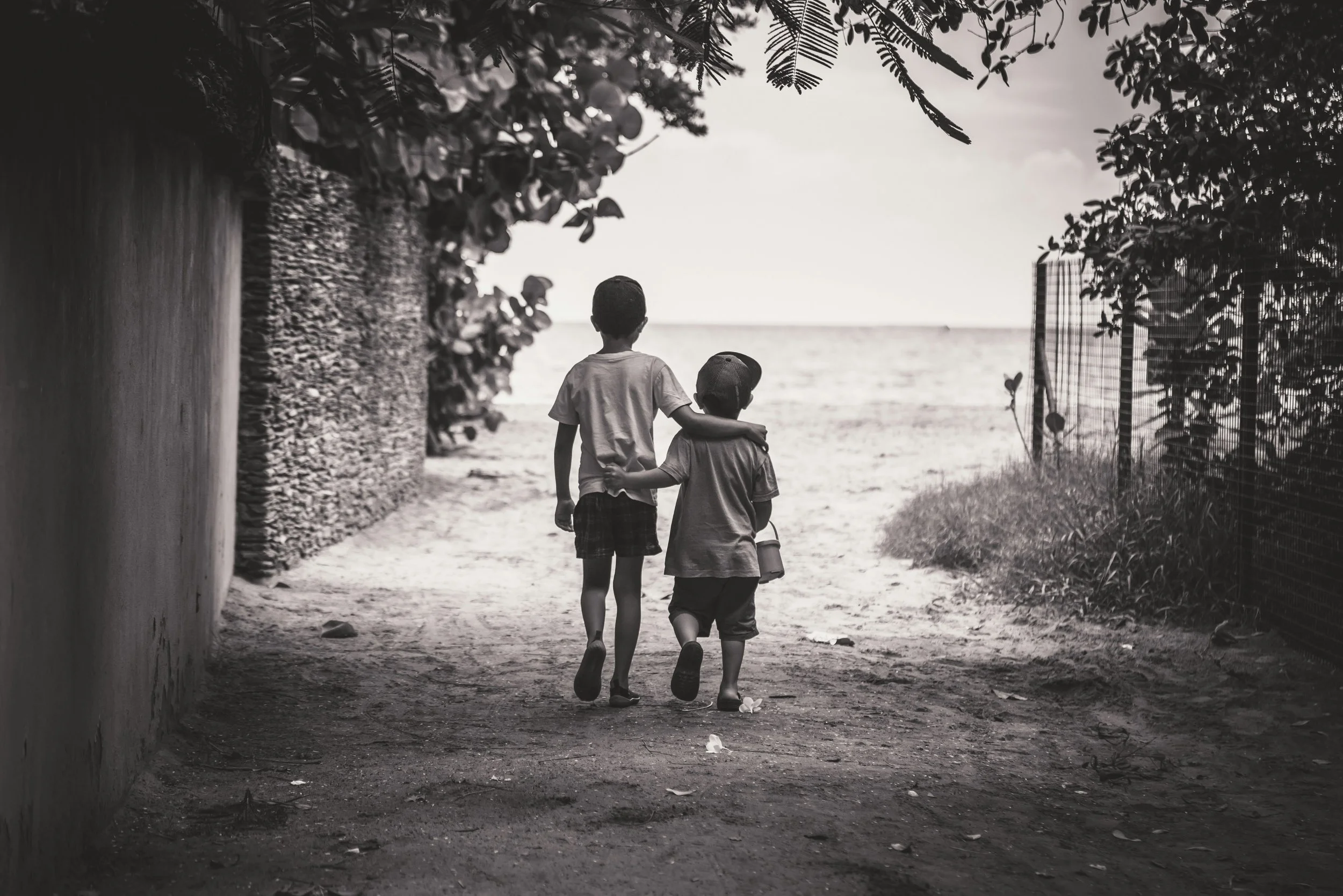 Two childredown a shaded path toward the water.