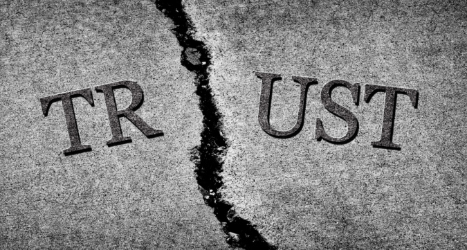the word trust is split in half showing that a traumatised family has broken trust