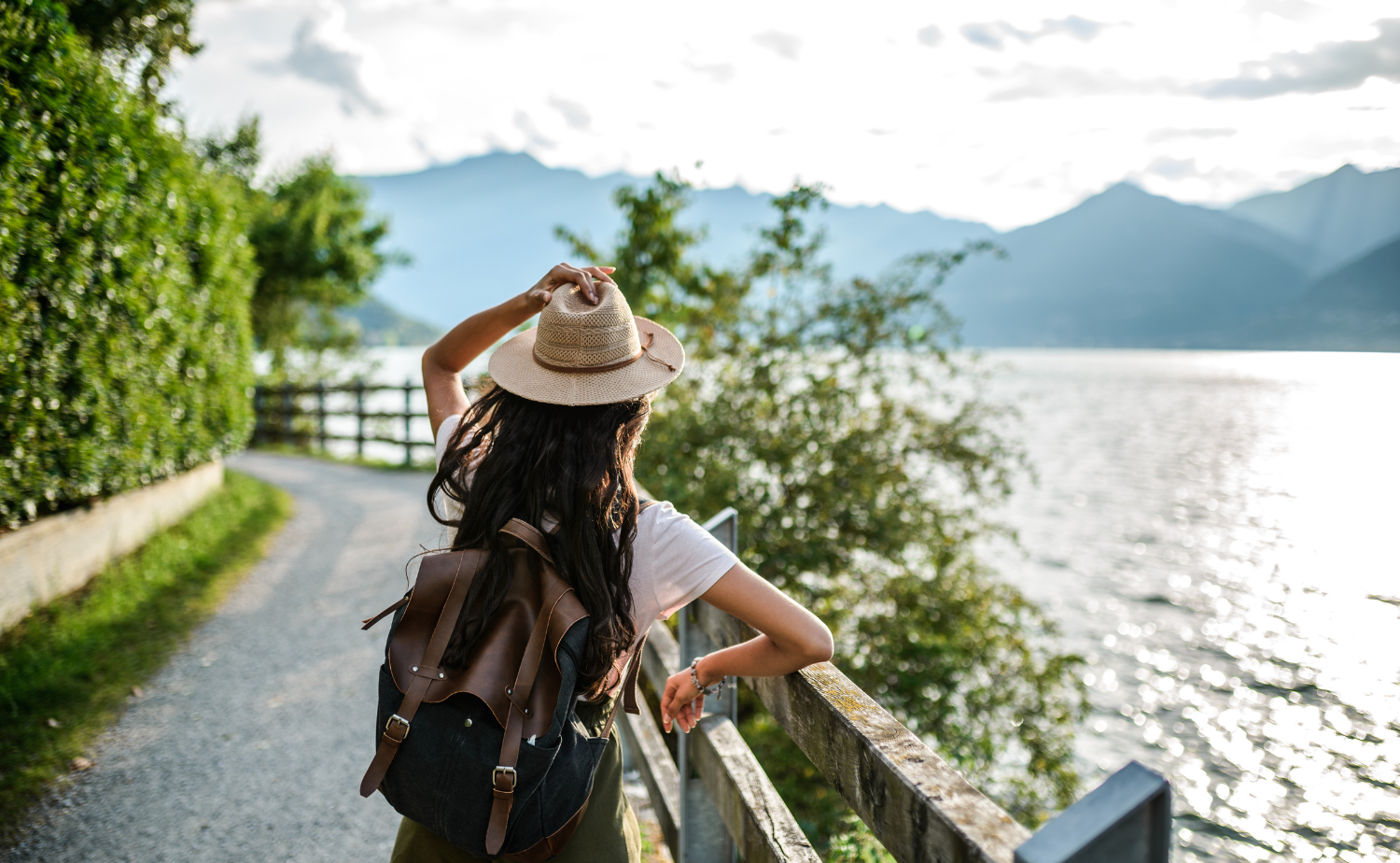 Solo traveler walking along a scenic European riverside path during a river cruise excursion