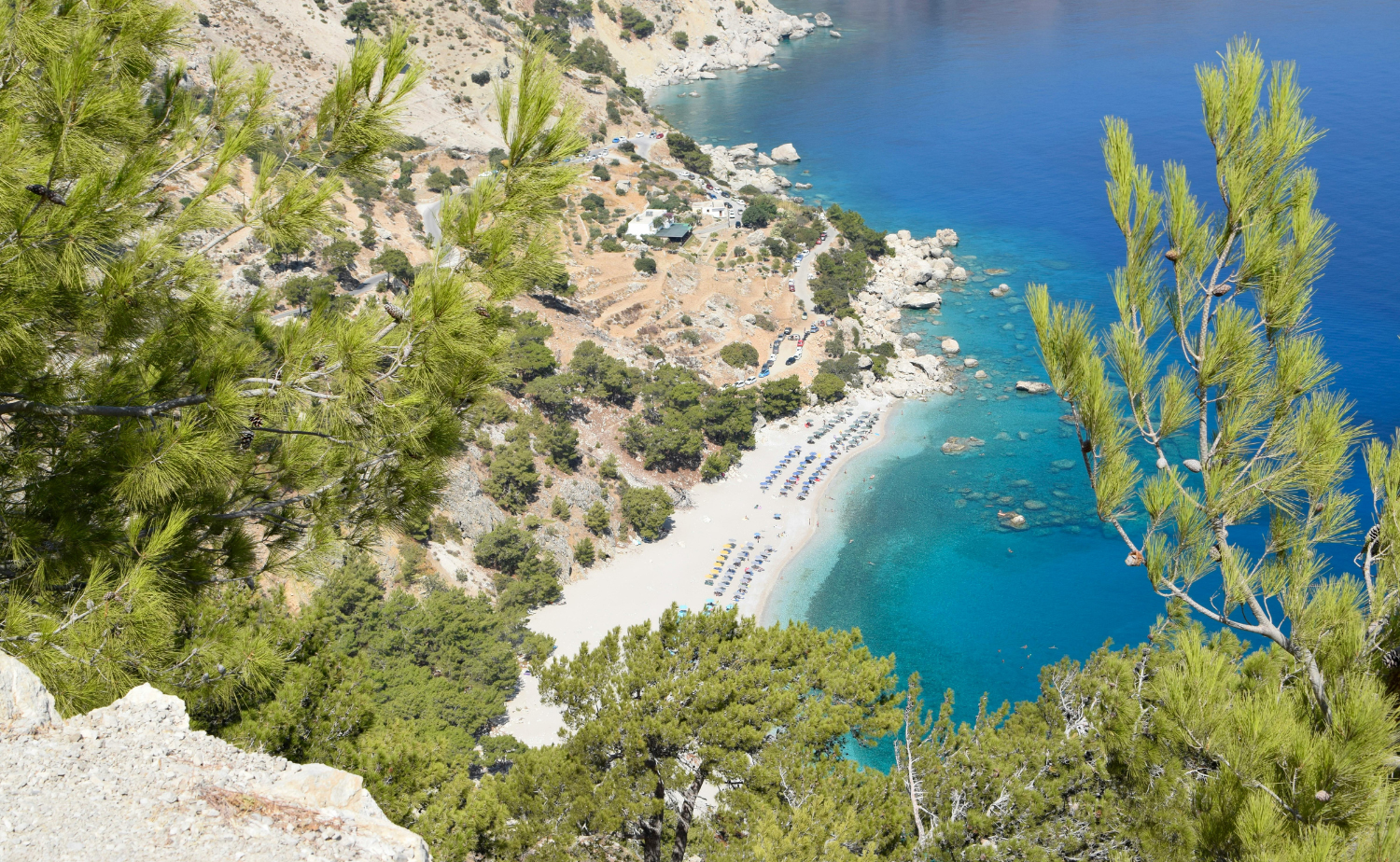 Turquoise water and a secluded beach surrounded by rocky hills on Karpathos in Greece’s Dodecanese islands