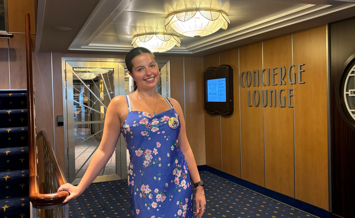 Audrey smiling in front of the Concierge Lounge aboard the Disney Dream