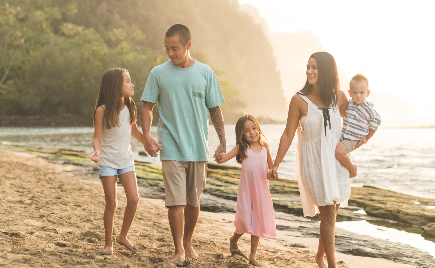 Family walking together along a sandy beach at sunset, showing a relaxed and meaningful travel experience that works well for families.