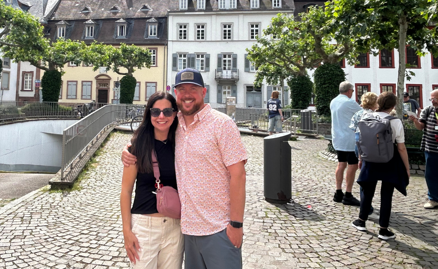 A couple smiling together in a charming European town during a summer vacation through Europe.