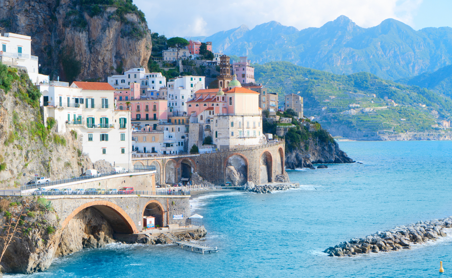 A colorful cliffside village overlooking the turquoise sea along the Amalfi Coast in Italy.