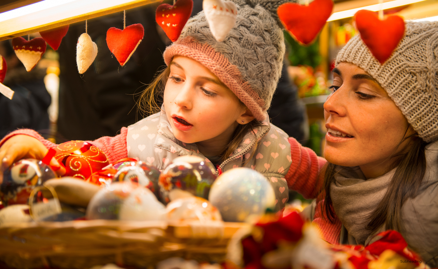 A mother and daughter exploring a Christmas market, looking at ornaments and decorations.