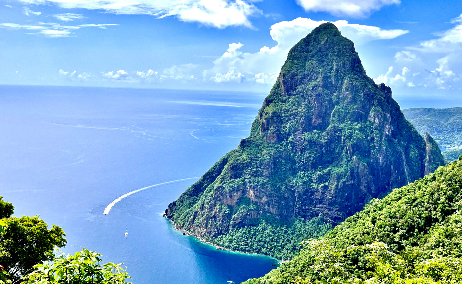 Dramatic coastal view of St. Lucia’s Pitons rising above the Caribbean Sea on a clear day.