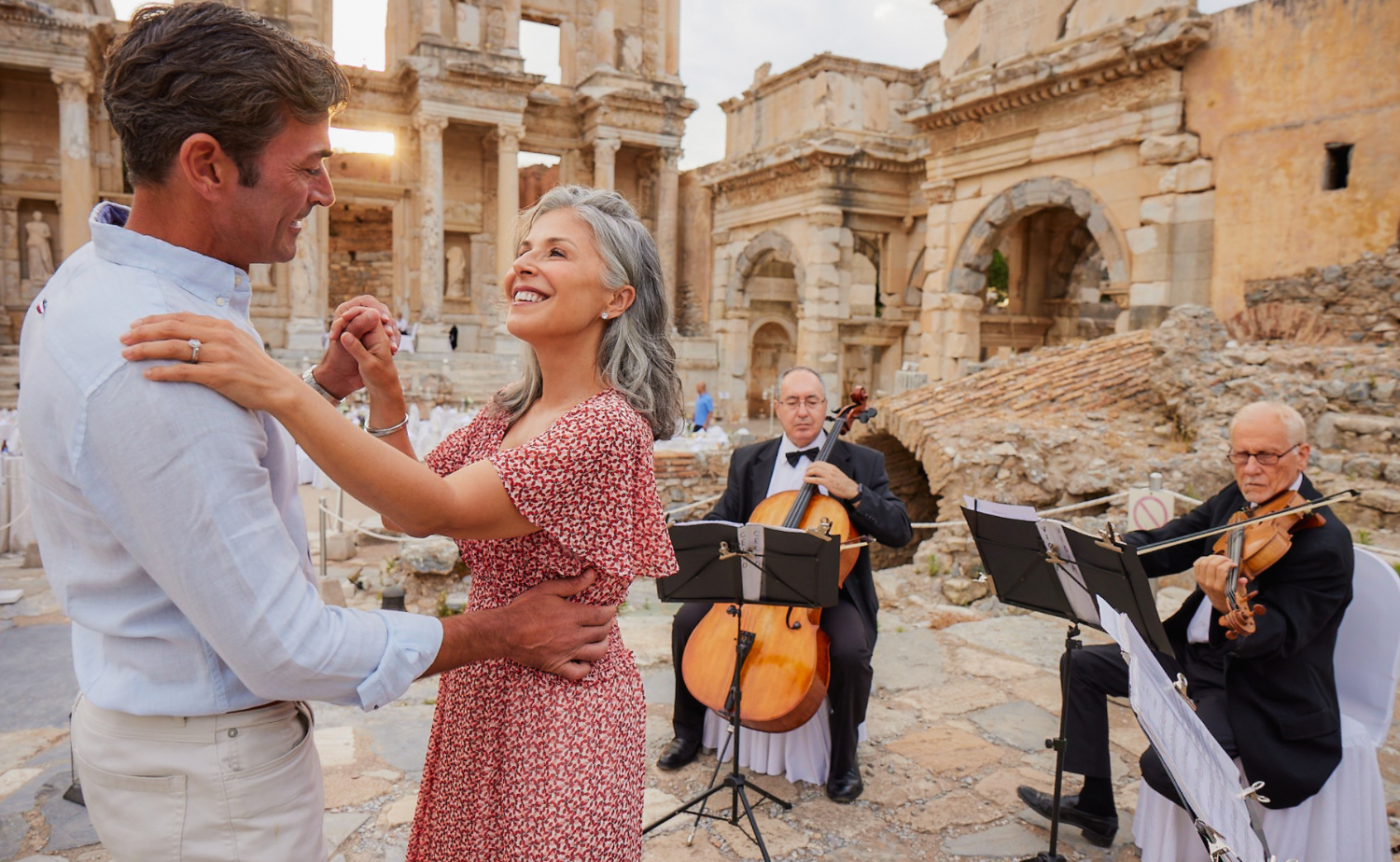 A couple dancing among ancient ruins while musicians perform during a private cultural event.